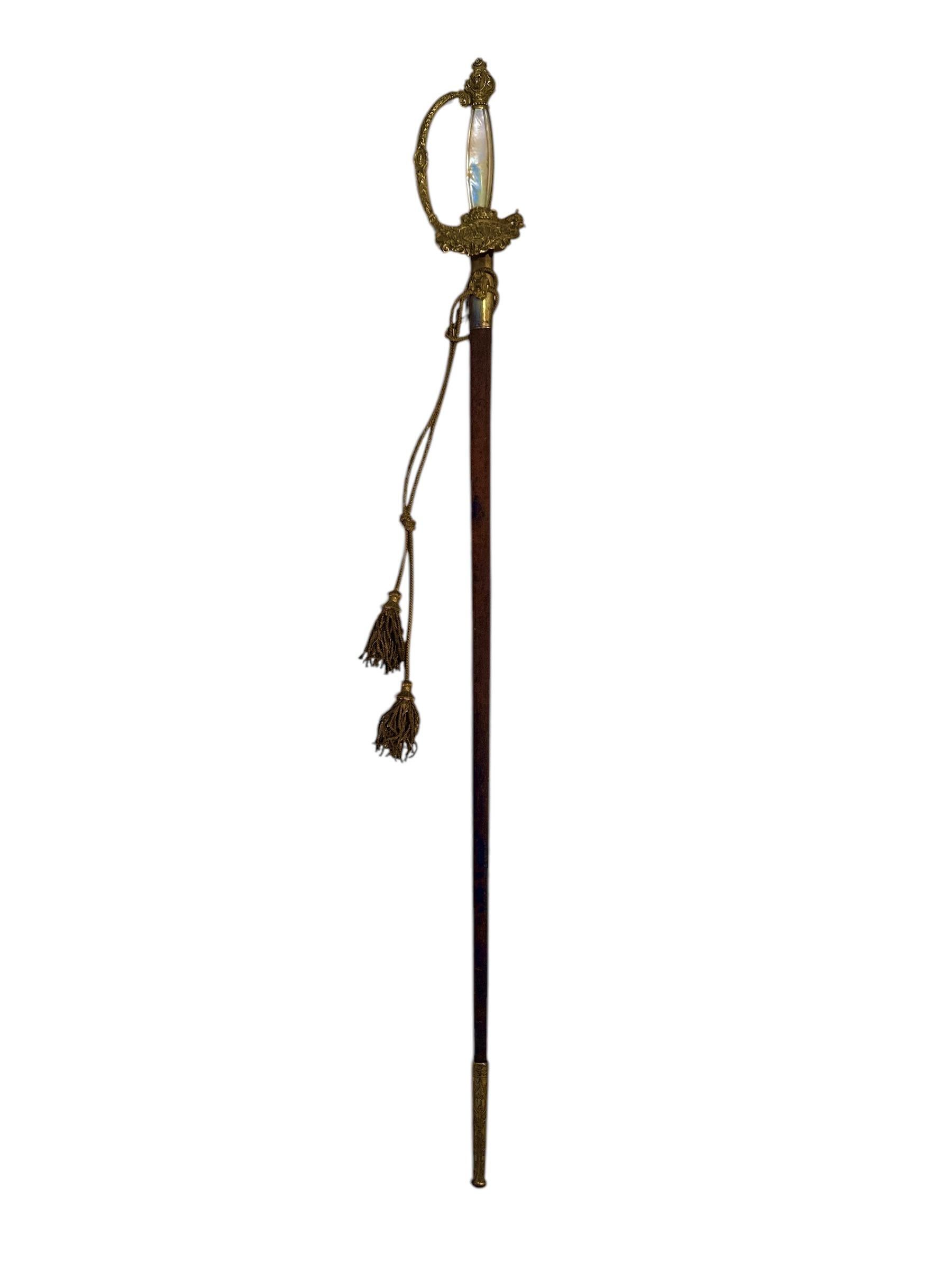 A Napoleon III sword in gilt brass. Handle is decorated with 2 mother of pearl plates. Urn shaped pommel. Knuckle guard transitioning into cross guard.
Guard plate with eagle. Black leather scabbard (upper layer is mostly gone).