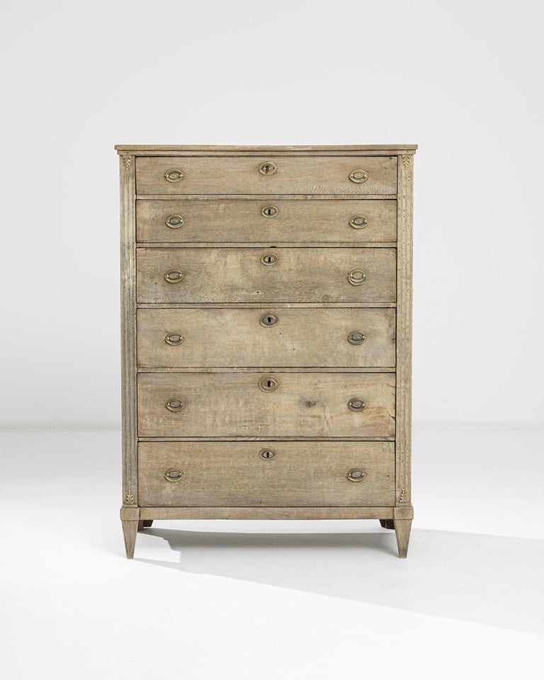 This antique oak dresser crafted in France circa 1880 adopts a distinctive Napoleon III angular shape punctuated by gracious tapered feet, fluted carvings on the sides and mitered corners of the top. It features two shallow and four deep drawers,