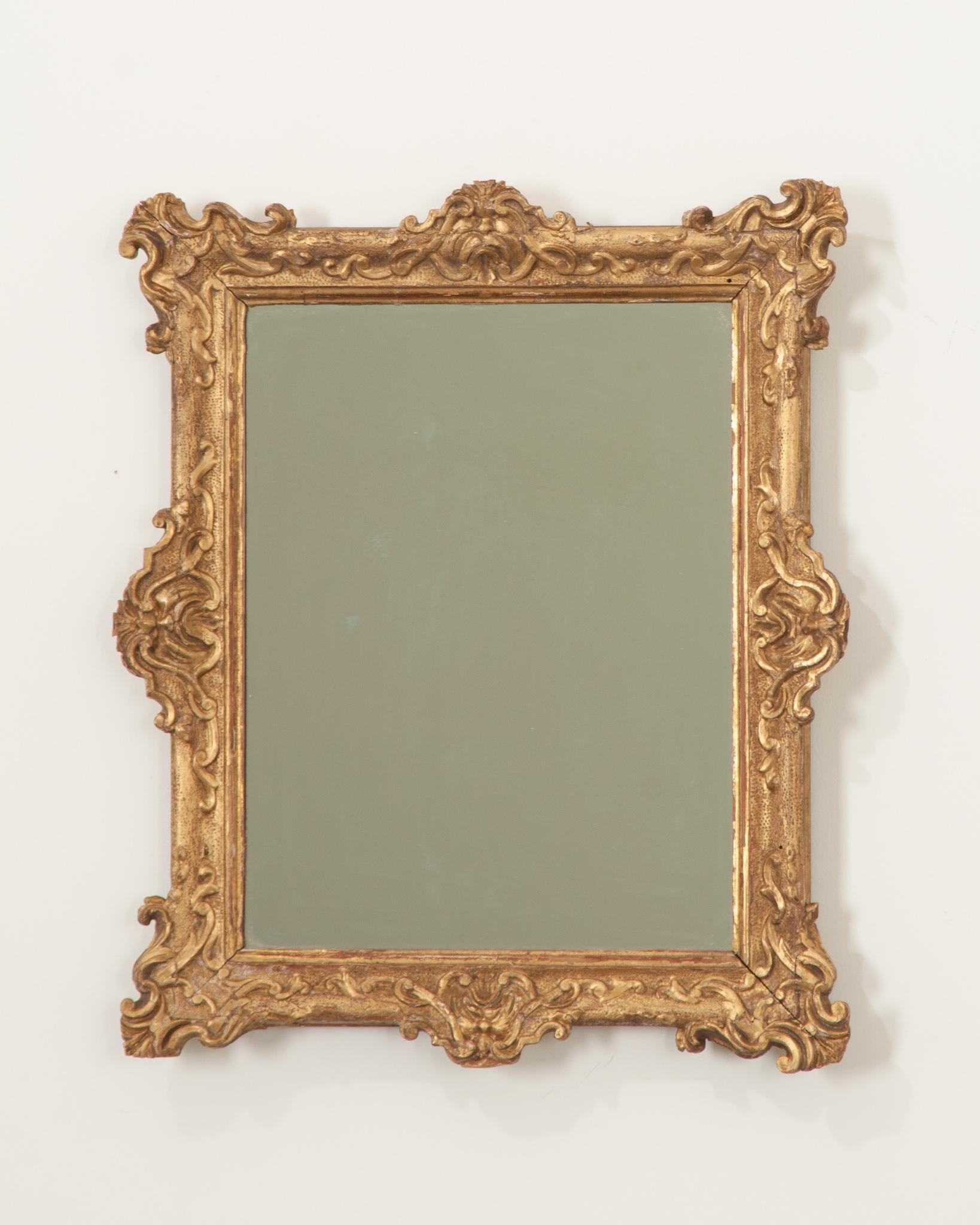 This darling Napoleon IV gold gilt mirror is the perfect accent in any space. The highly decorative frame has gained a wonderful patina and houses a new mirror plate. Ready to be hung- the back is already fixed with a bracket. Make sure to view the
