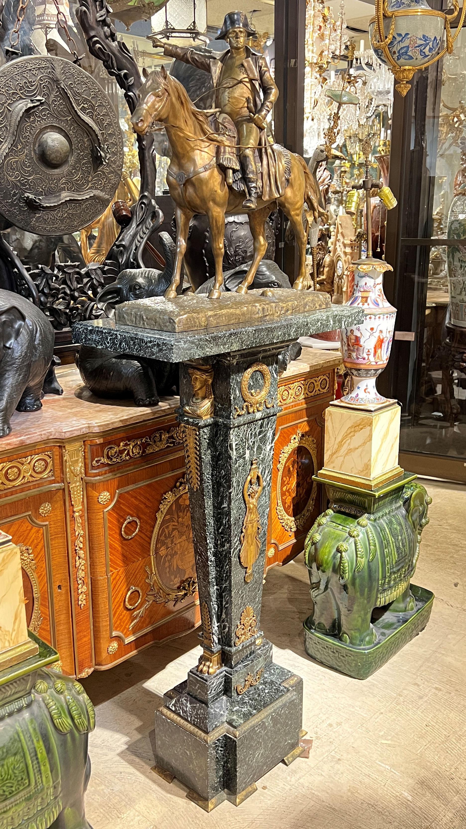 Patinated bronze sculpture of Emperor Napoleon on horseback after the original model by Henri Louis Levasseur (1853-1934), mounted to the rotating top of a marble pedestal with neoclassical gilt bronze mounts in the French Empire style.  Bronze