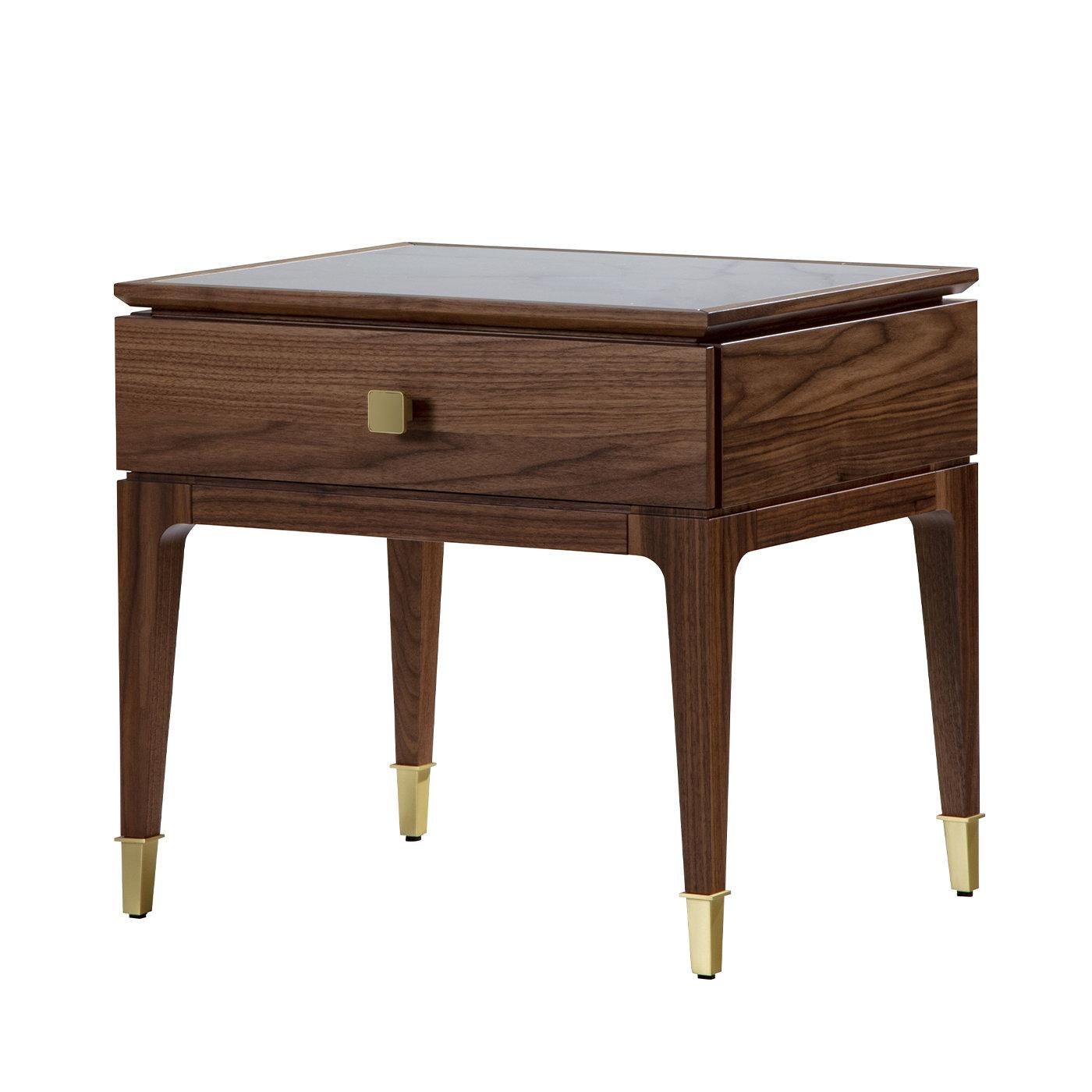 This classy nightstand merges fine influences from Art Deco and architecture typical of the city of Nara, Japan. Its structure in natural-finished walnut includes four tapered legs and provides a single drawer to store a favorite bedtime book. Both