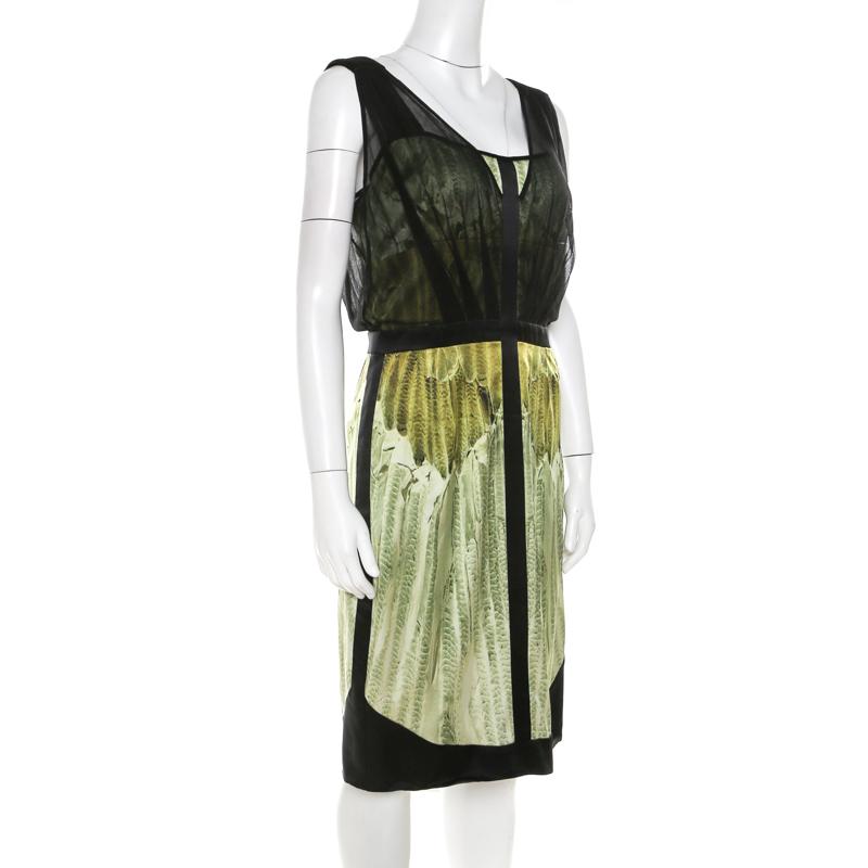 This Narciso Rodriguez dress, masterfully tailored from quality fabrics, is a reflection of feminine fashion. It is designed with colours of green and black, a back zipper and mesh overlay. The dress is the right fusion of sophistication and comfort