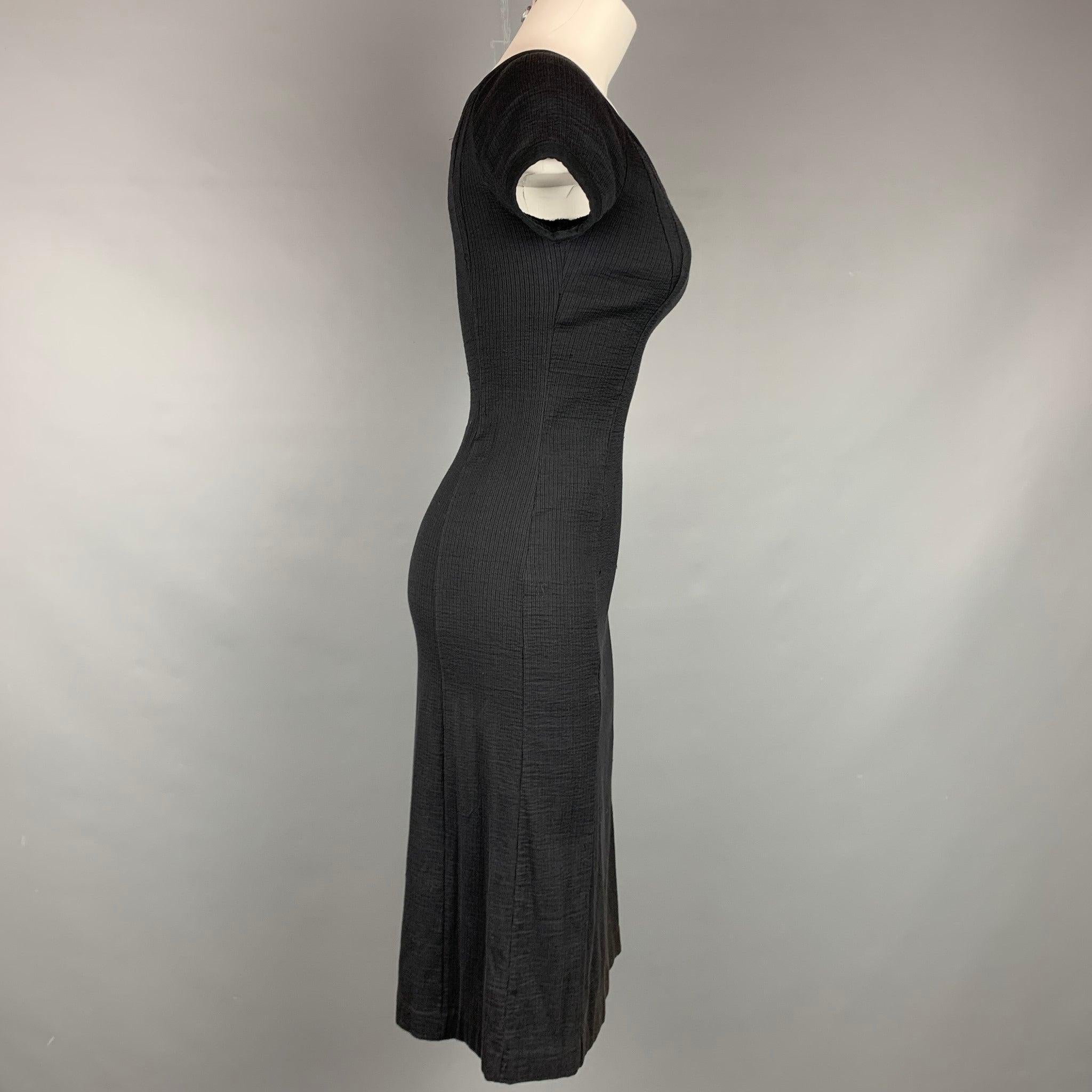 La robe NARCISO RODRIGUEZ se présente sous la forme d'une robe noire en coton/polyamide côtelé, avec des manches courtes et une encolure en V. Fabriqué en Italie.
Etat d'occasion. 

Marqué :   I 38 / F 34 / D 34 / GB 6 / USA 2 

Mesures : 
 
Épaule