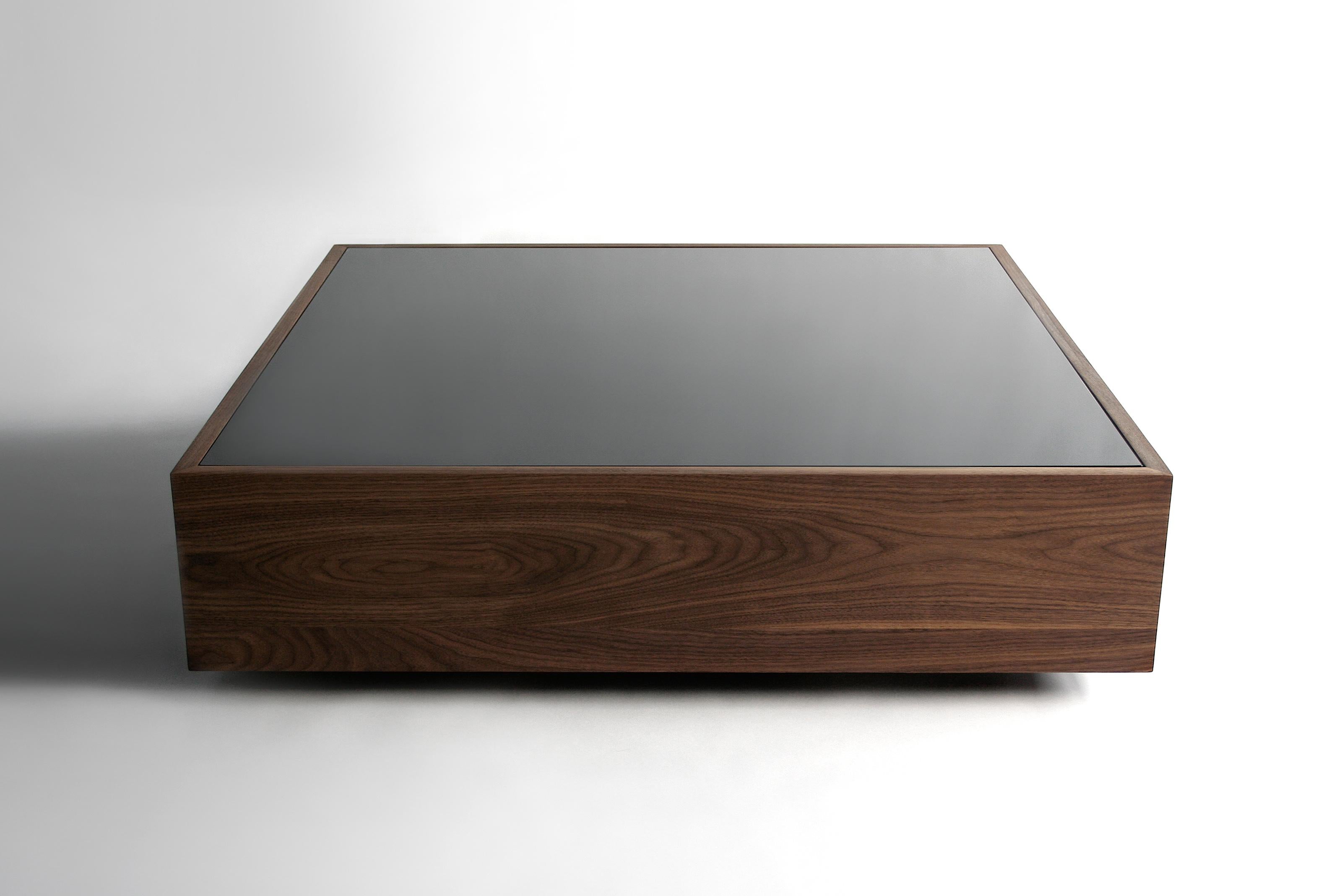 Narcissist Version C Coffee Table by Phase Design
Dimensions: D 106.7 x W 106.7 x H 30.5 cm. 
Materials: Walnut. 

Solid hardwood shell, available in walnut, white ash, white oak, or ebonized oak with tempered black spandrel glass top. Available in