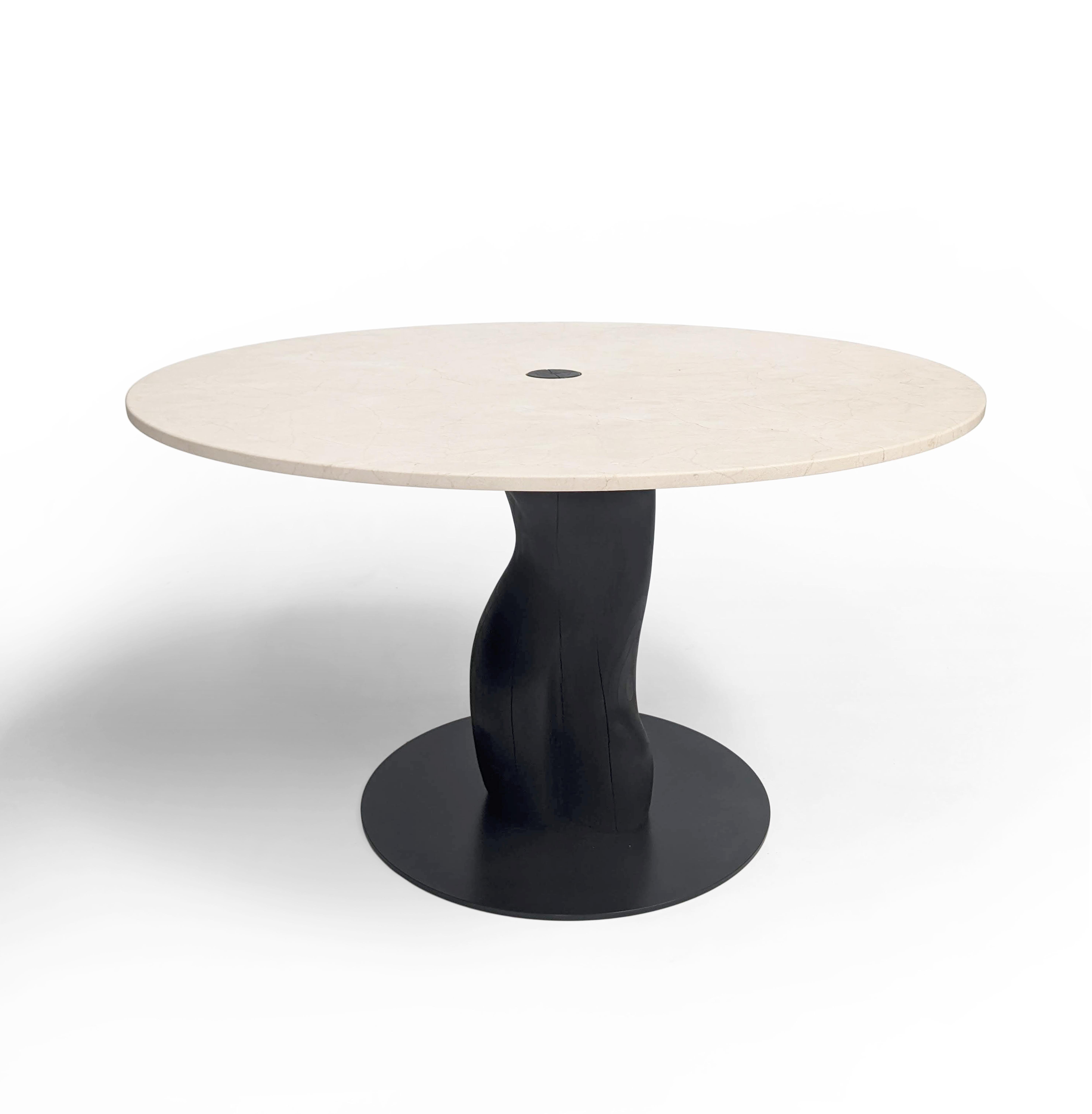 Narco Teak Collection Dining Table Round by AMBER x IÑIGO CALLEJA
Dimensions: D 130 x H 75 cm. 
Materials: Dry Teak Trunks Base, charred and stained pitch black, Ivory cream Marble top, matt finish.

Iñigo Calleja is an engineer, designer and