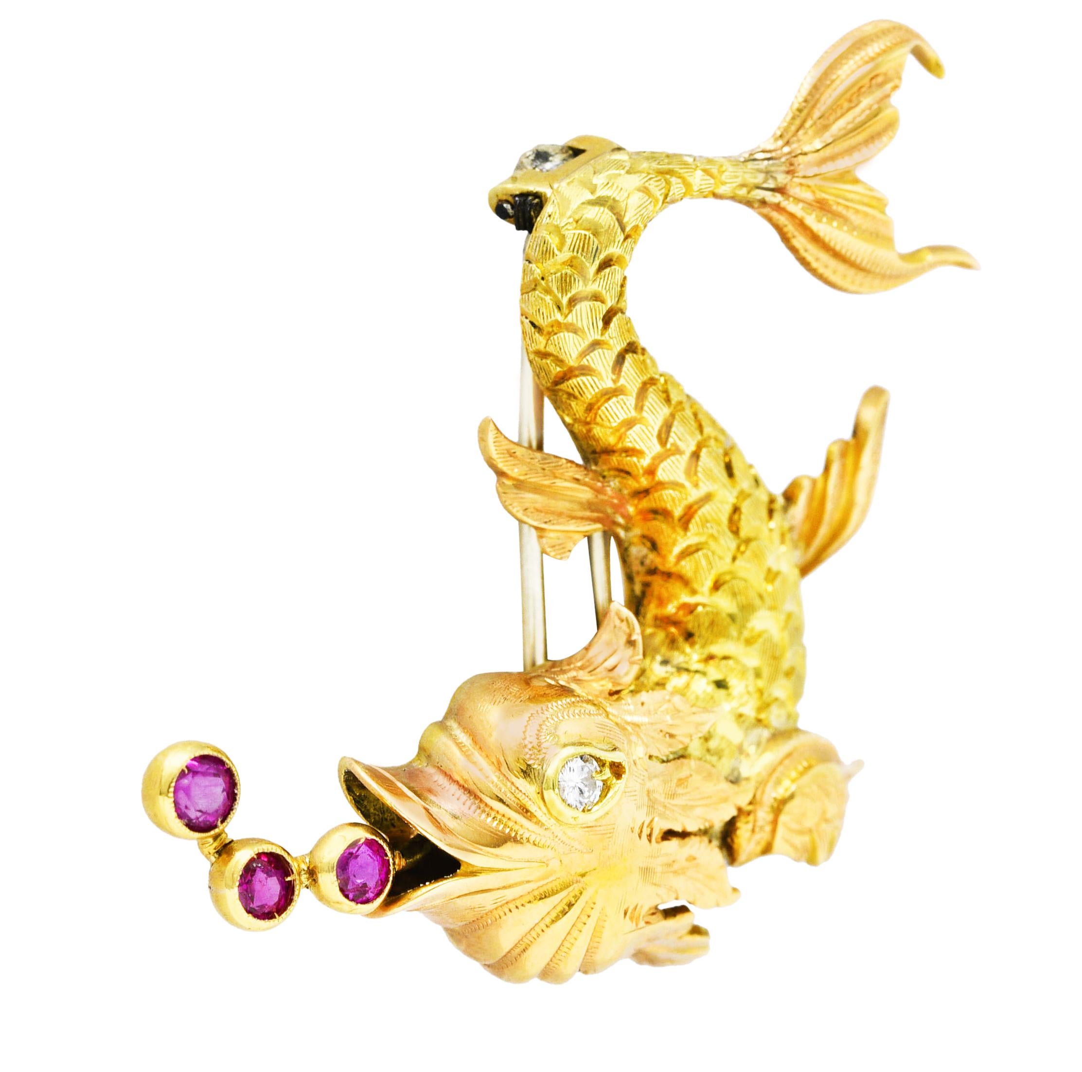 Brooch is designed as a swimming fish featuring a scaled body with fine engraving throughout. Accented by furling rose gold fins and head with bezel set round cut ruby bubbles rising from mouth. Weighing approximately 0.36 carat total - transparent