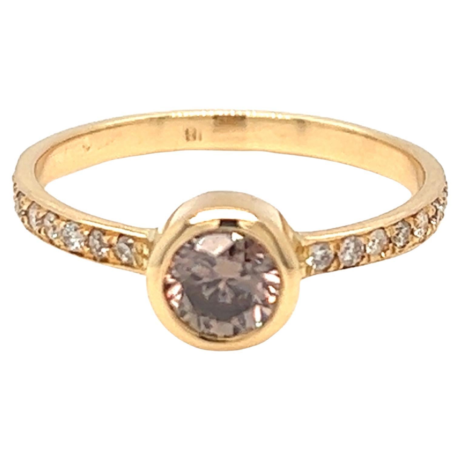 Designed and handcrafted by Nari Fine Jewels in Beverly Hills, California, the 0.50 carat cognac colored round brilliant cut diamond is set in 18K yellow gold bezel and accented with 0.10 carat small diamonds on the ring band. The ring is currently