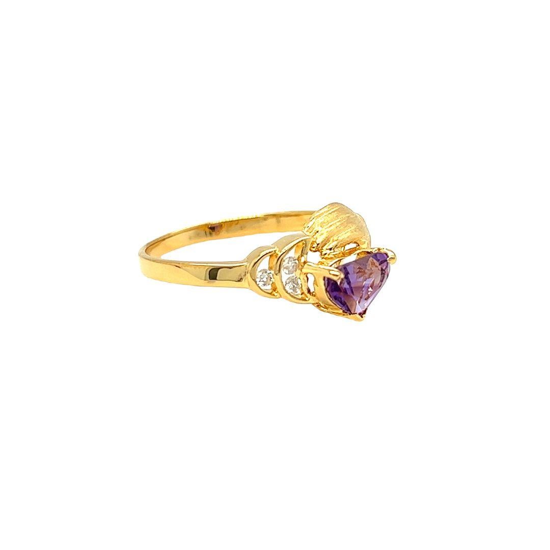 This stunning Claddagh ring symbolizes everlasting love and loyalty. Crafted from 14k yellow gold, it features a 0.45 carat heart-shaped amethyst, 7 x 5 mm, and three channel set diamonds in crescent moons, totaling 0.04 carat in weight. The matte