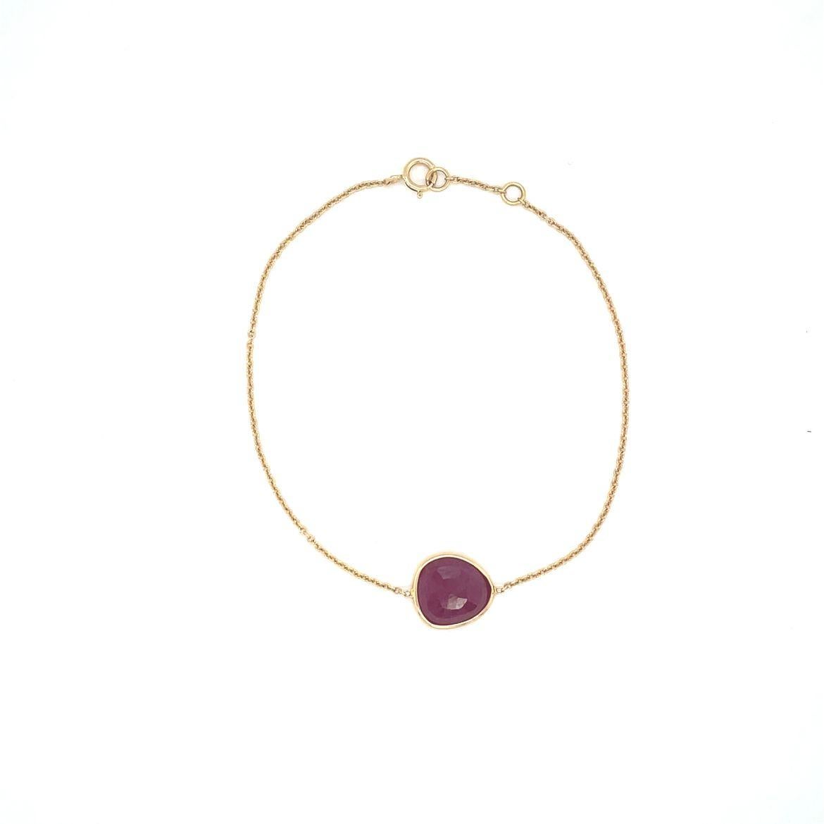 This lovely bracelet is handcrafted in 18K gold and features rose-cut irregular oval shaped single drop ruby. The Ruby is natural, weighting approx 0.76 carats, wrapped in 18K yellow gold, and floating at the center of the chain. Designed and