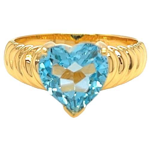14K Yellow Gold cocktail Ring featuring a stunning prong set heart shaped Blue Topaz. The ring showcases a bold and perfectly blue heart shaped Blue Topaz gemstone, measuring approximately 9.3 mm x 9 mm and weighing 3 carats. With its bold fluted