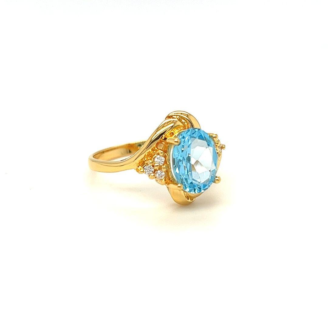 Der Ring mit gedrehtem Schaft ist aus 14 Karat Gelbgold gefertigt und zeigt einen atemberaubenden ovalen Blautopas-Halbedelstein in der Mitte, der etwa 10 mm x 8 mm misst und 3 Karat wiegt. 

Ein wunderschöner Blautopas im Ovalschliff ist perfekt