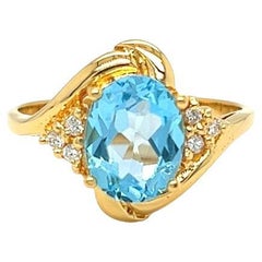 Bypass-Ring aus 14 Karat Gelbgold mit ovalem blauem Topas und Diamanten von Nari Fine Jewels