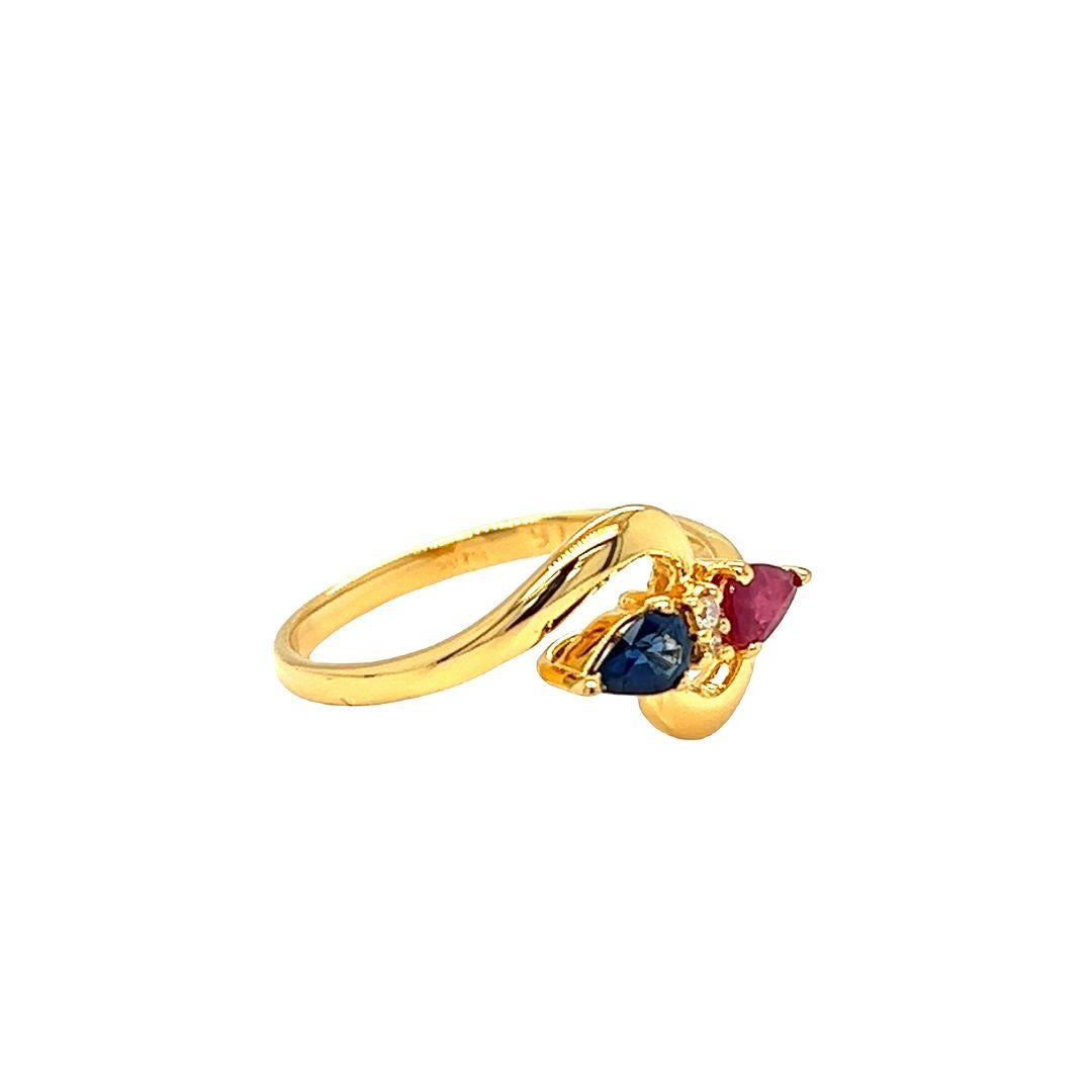 Sparkle with confidence with this 14k yellow gold ring showcasing east-west pear shaped ruby and Sapphire, all totaling 0.50 carat. and with two diamonds nestled in the middle totaling 0.05 carat.

The face of the ring measures 10.3 mm and sits 4.4