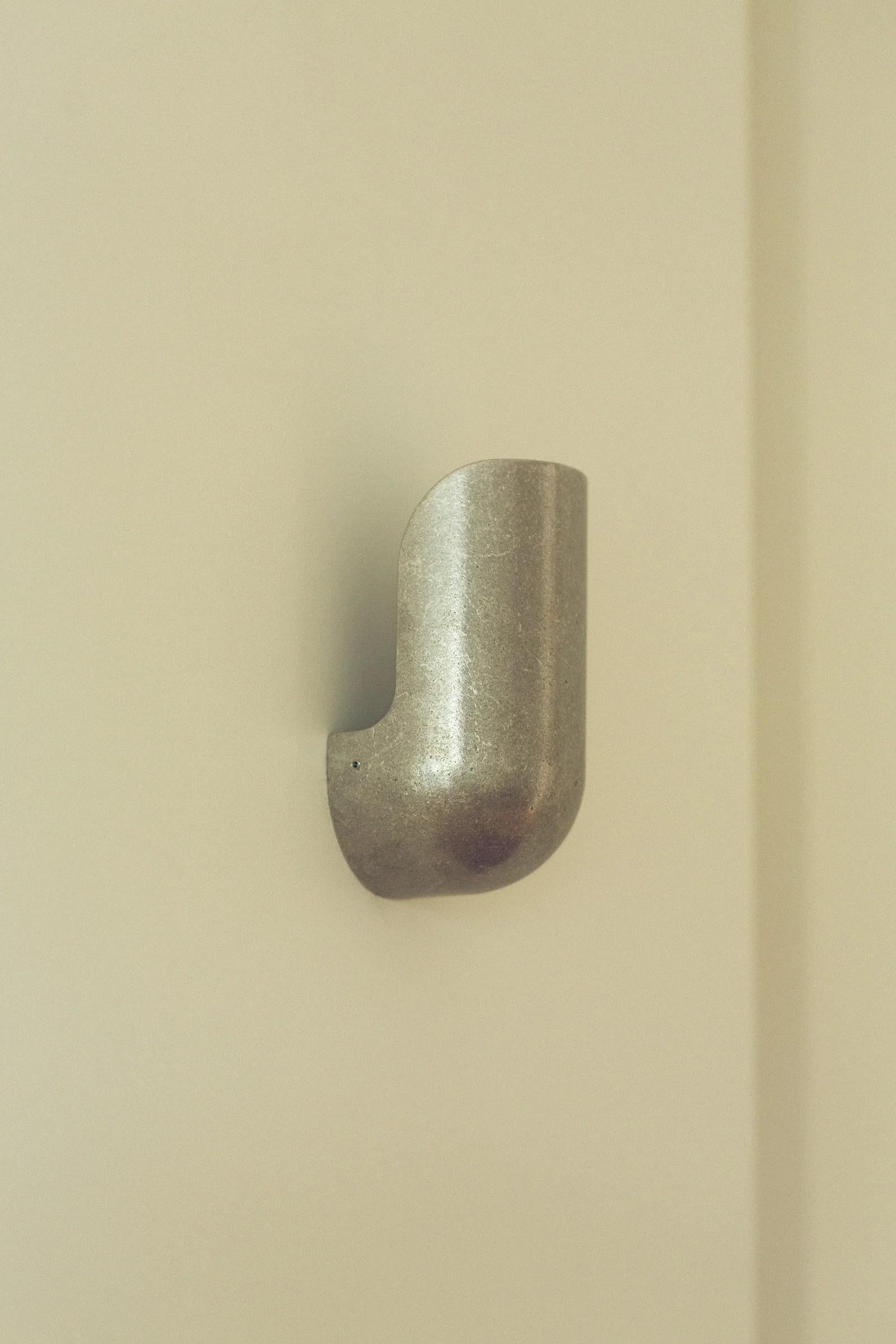 Aluminum Elbow Wall Light by Henry Wilson
Dimensions: W 10 x D 9.5 x H 20.5 cm
Materials: Aluminum.

Available in blackened, aluminum, and brass.

Elbow Wall Light is available in two widths and three material finishes. Its form resembles an