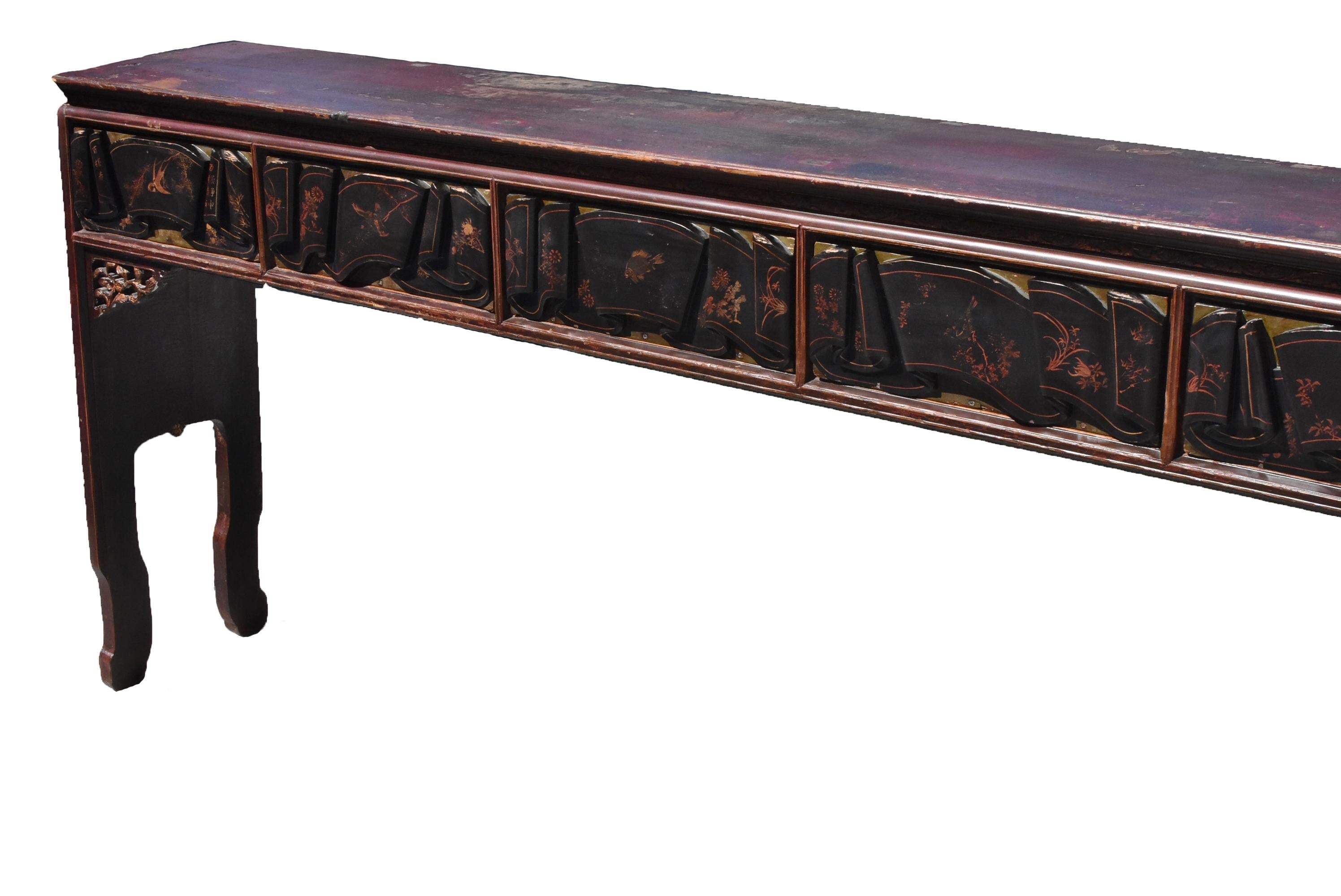 A rare, beautiful table from 19th century, China's southern Fu Jian Province. A solid single board top, of tenon and mortise construction, extends nearly 7' long, above a cinched waist and carved strip apron displaying an eternal foliage pattern.