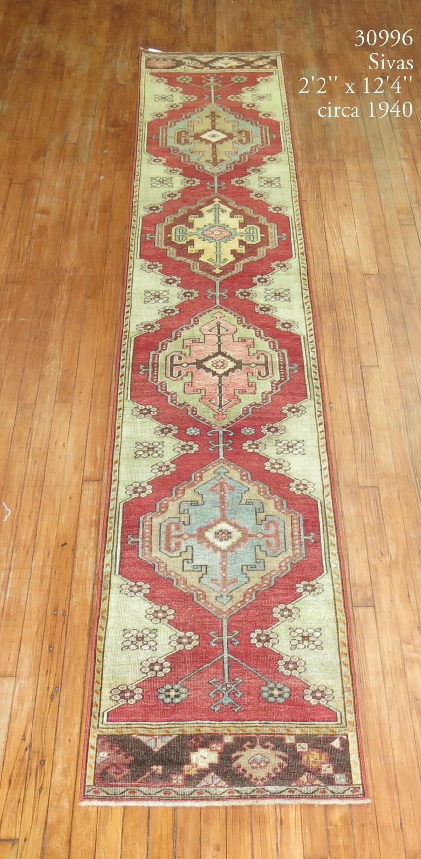 Narrow Turkish Sivas runner highlighted by sky blue and green accents on a red field, circa 1930

Measures: 2'2