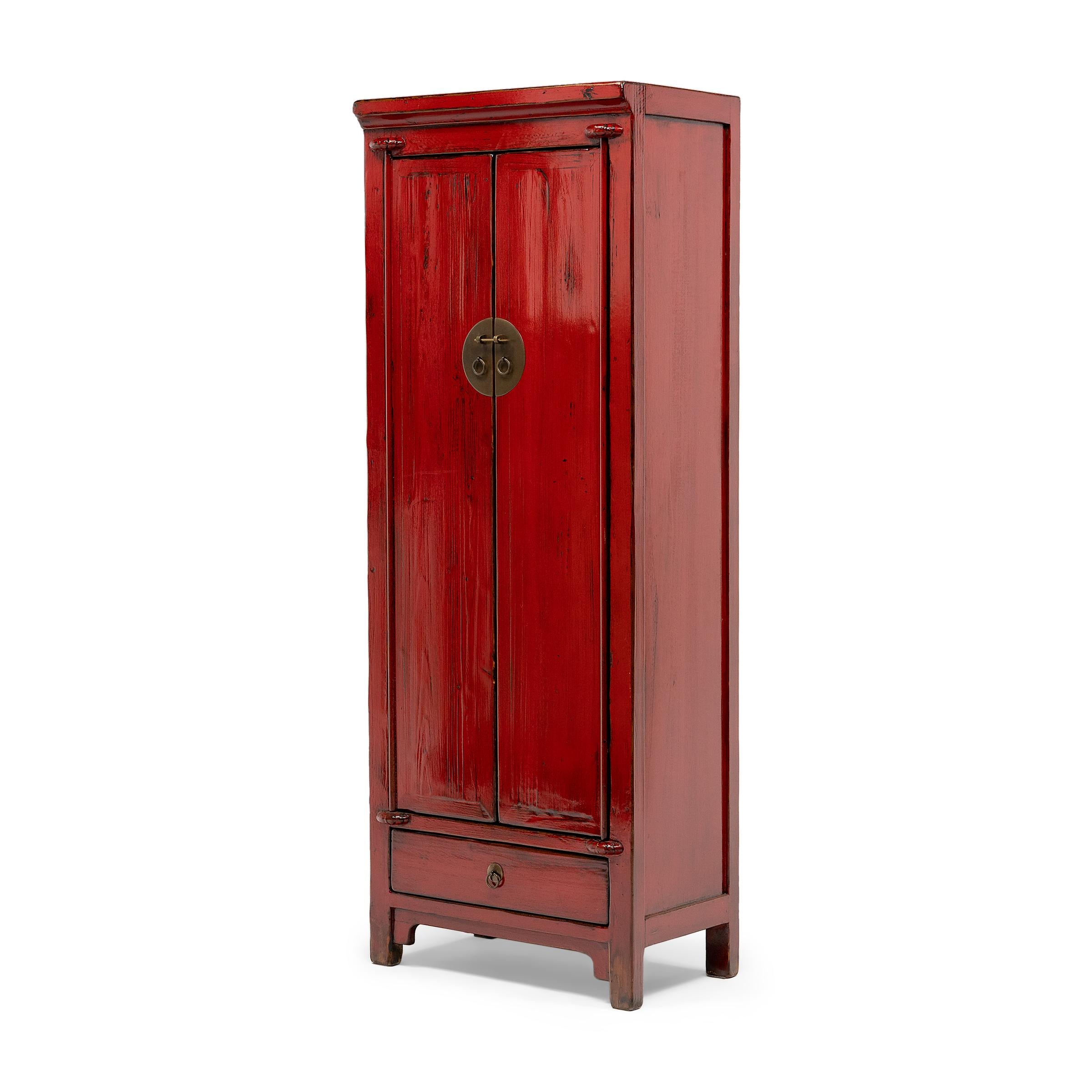 The essence of traditional Chinese furniture is fully expressed in the simplicity and graceful presence of this 18th-century cabinet crafted in the Shanxi province. Made of pine wood with traditional joinery techniques, the narrow cabinet stands