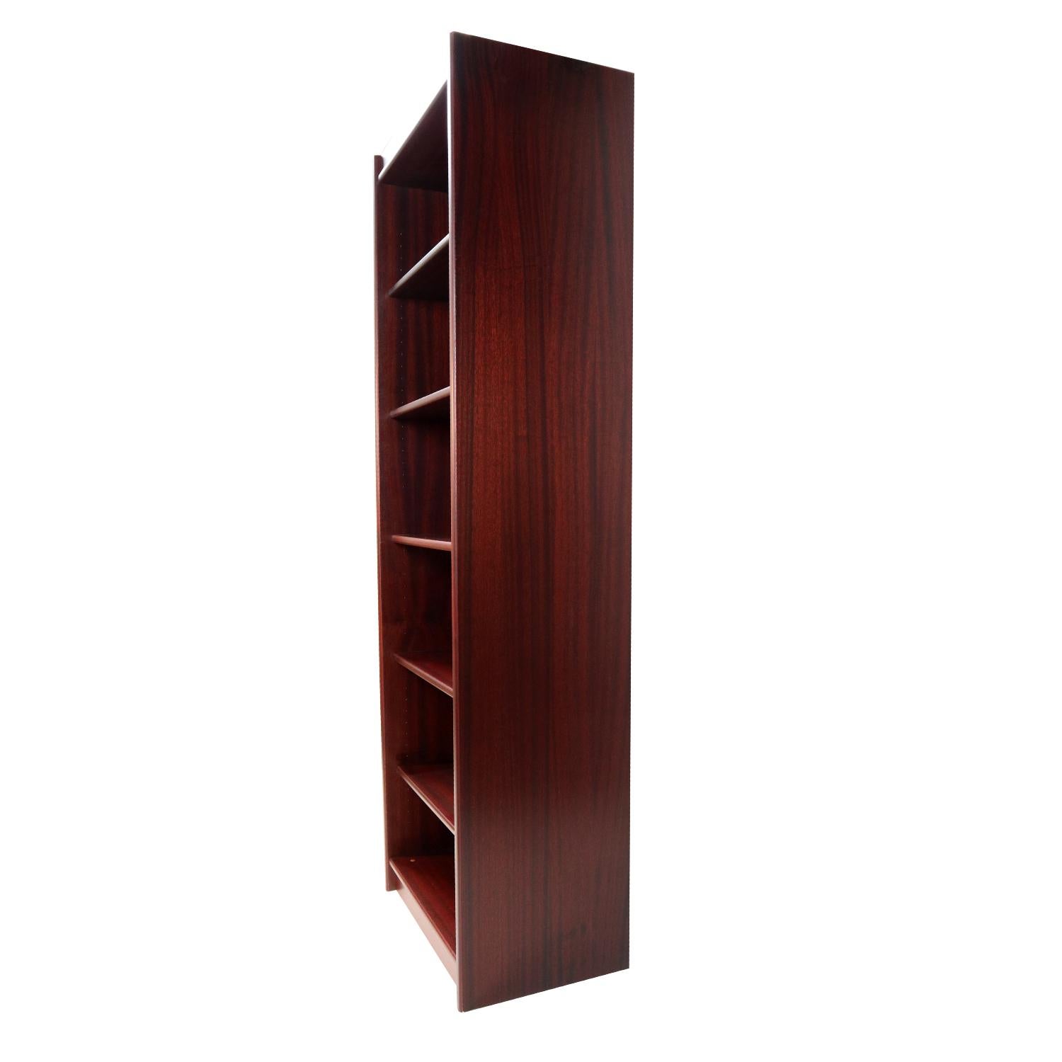 Exceptionally crafted Danish modern rosewood bookcase with adjustable shelves. This bookshelf is unusual for it’s narrow dimension. The width is 24.75? wide, much slimmer than a typical bookcase. The slender size lends itself to versatility. The