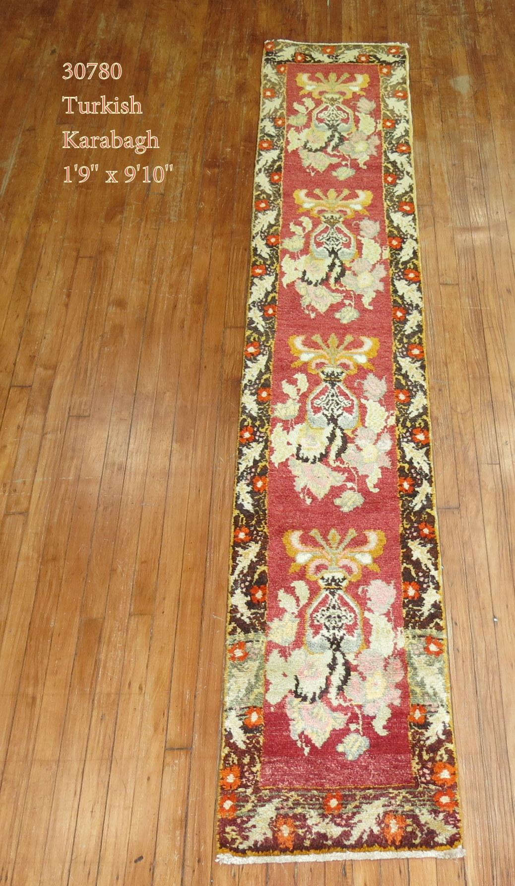 Mid-20th century red field Turkish runner with an all over repetitive flower design.

Measures: 1'9'' x 9'10''.