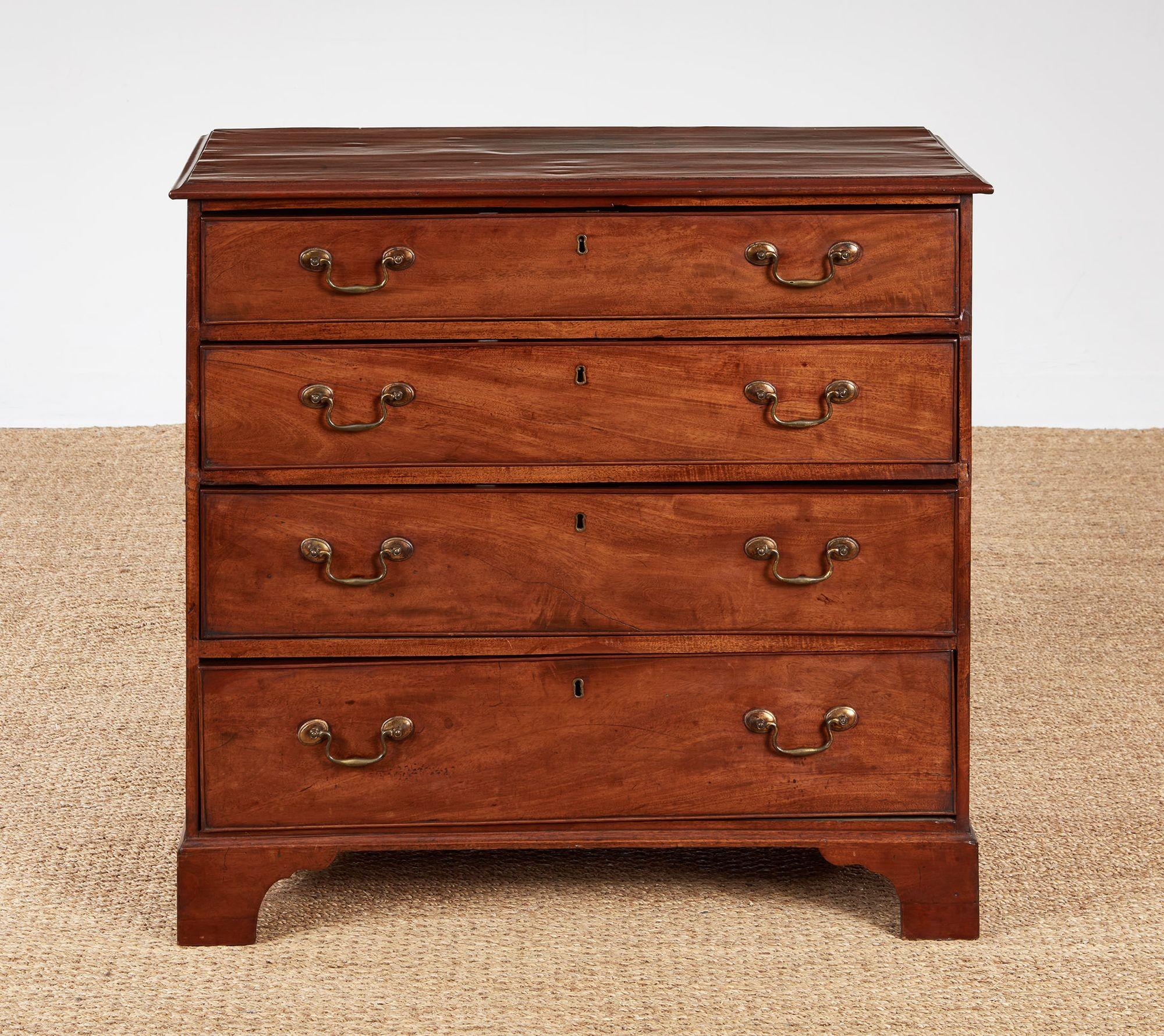 A George III chest of four drawers of good quality made with tightly grained mahogany featuring top with thumb molded edge, brass bail pulls and original bracket feet.  England, circa 1800.   Hard-to-find narrow proportions.  Slight warping of