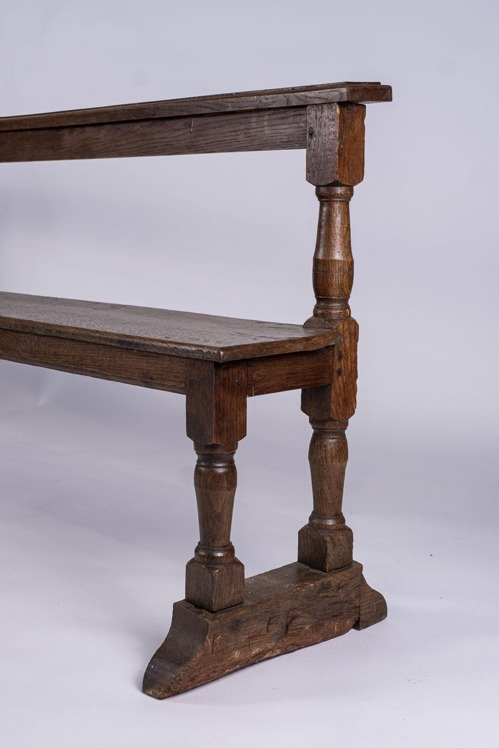 Narrow Belgian brown oak bench circa 1870-1890 from a monastery. Simple lines and classic shape. Perfect seating for the foot of a bed or narrow hallway. Seat measures: 18 inches high x 69.5 inches wide x 10.25 inches deep.