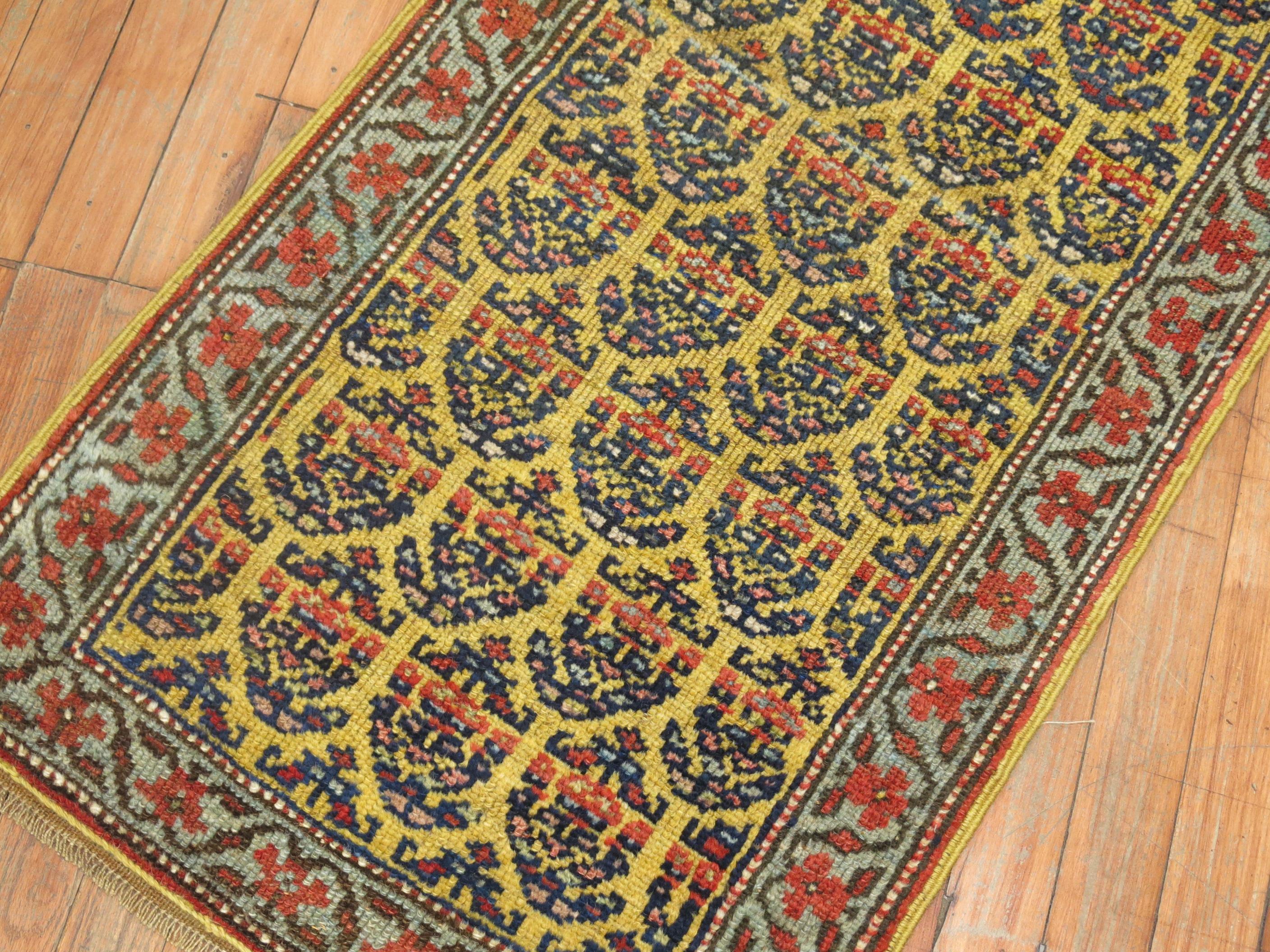 Very narrow finely woven one of a kind Persian runner with a navy paisley motif on a yellow field.

Measures: 1'11