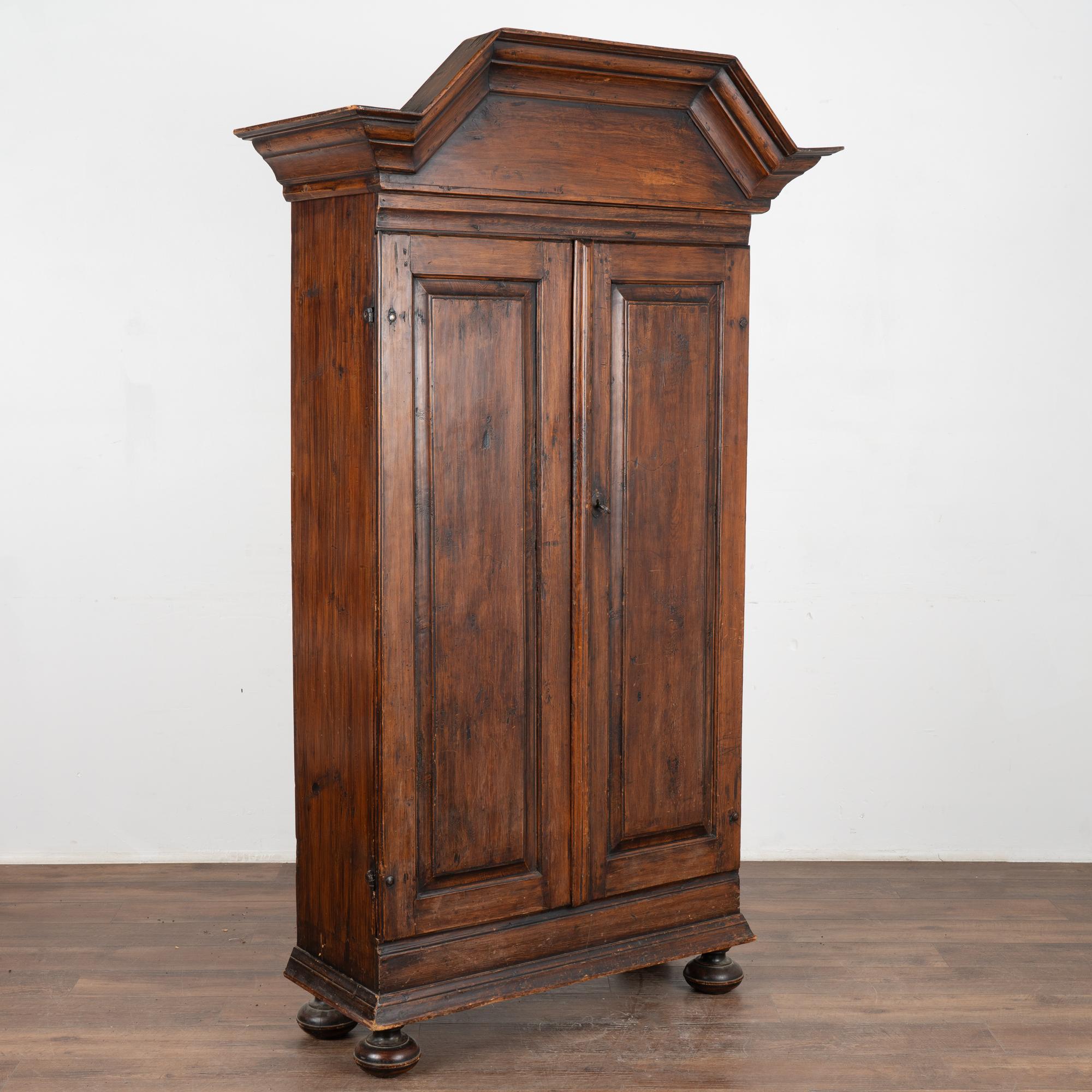 Lovely dark pine narrow armoire from the Swedish countryside which dates to the early 1800's.
Note the raised bonnet or 
