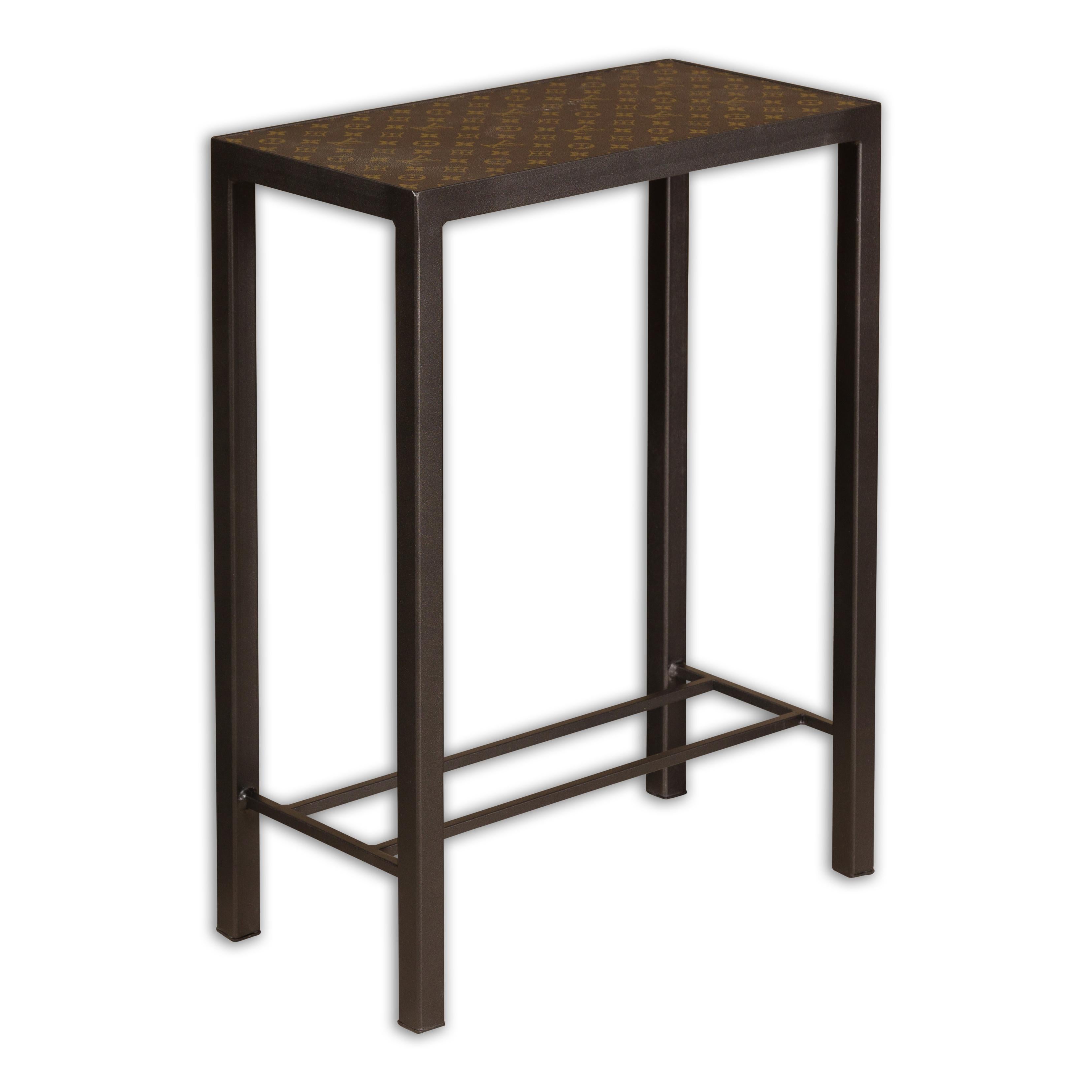 A narrow side table made of a Louis Vuitton leather top, mounted on a custom metal base. Step into a world of refined luxury with this exquisite narrow side table, featuring a top crafted from authentic Louis Vuitton leather, seamlessly mounted on a