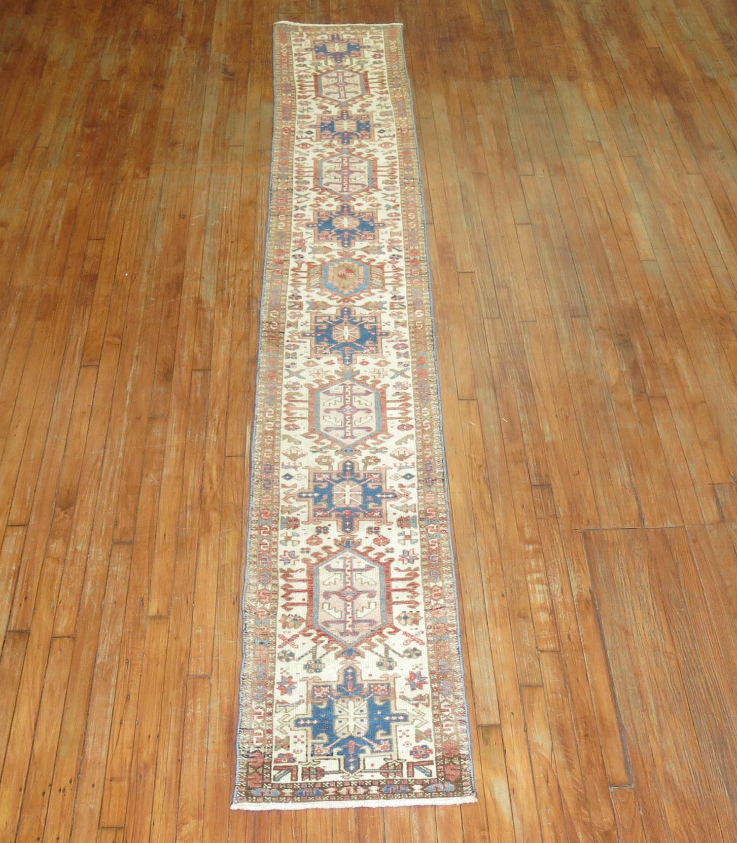 Very narrow one of a kind Persian heriz runner from the second quarter of the 20th century. Pink, rust, blue tones on an ivory ground. The size is original, circa 1940s.

Measures: 1'10