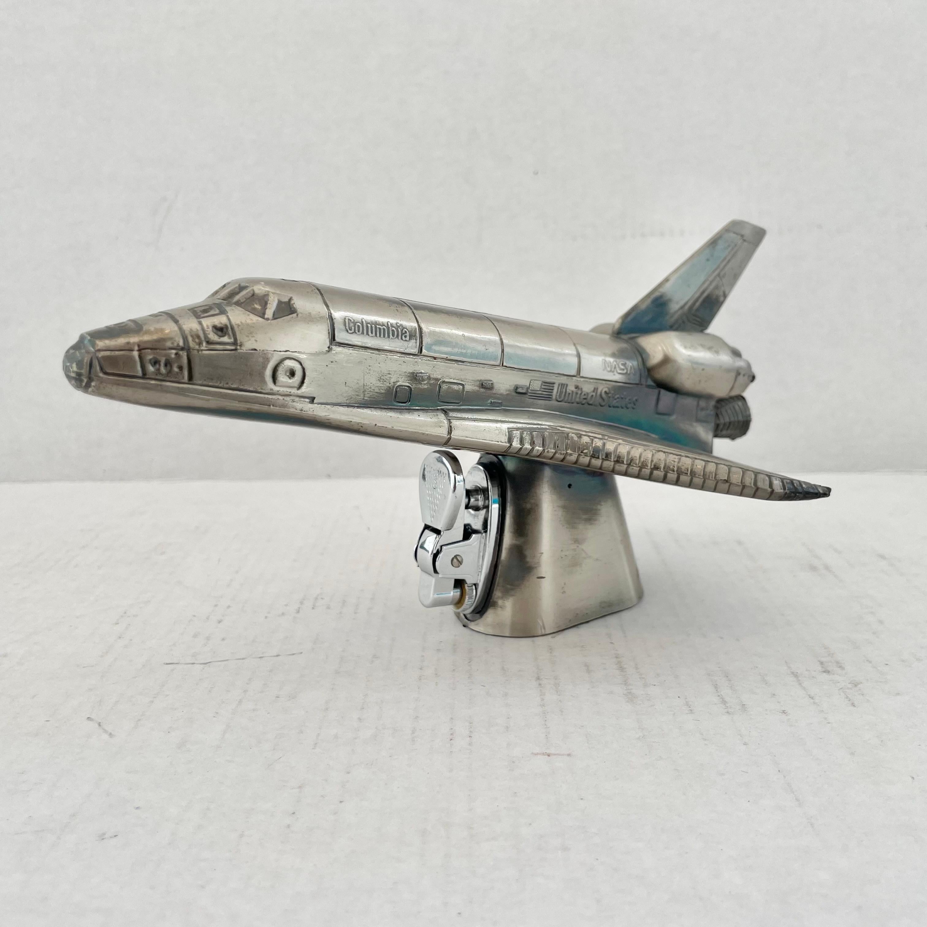 Cool vintage table lighter in the shape of a Nasa space shuttle. Made in Japan, 1980s. This piece has great balance and details. Cool tobacco accessory and conversation piece. Working lighter. Good vintage condition.