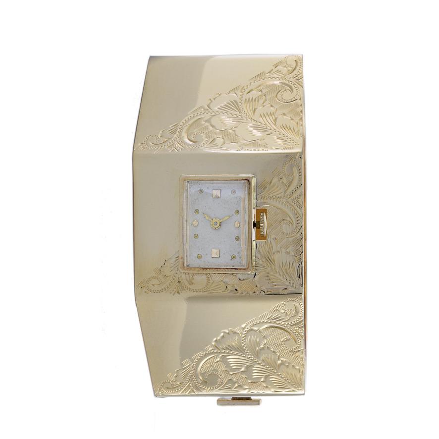 This is an elegant 1950's Nastrix cuff watch. The cuff is 14K yellow gold and is engraved with a beautiful period design. The watch is powered by a high grade 17 jewel manual wind movement. The cuff measures 32mm wide. This 14K gold cuff watch