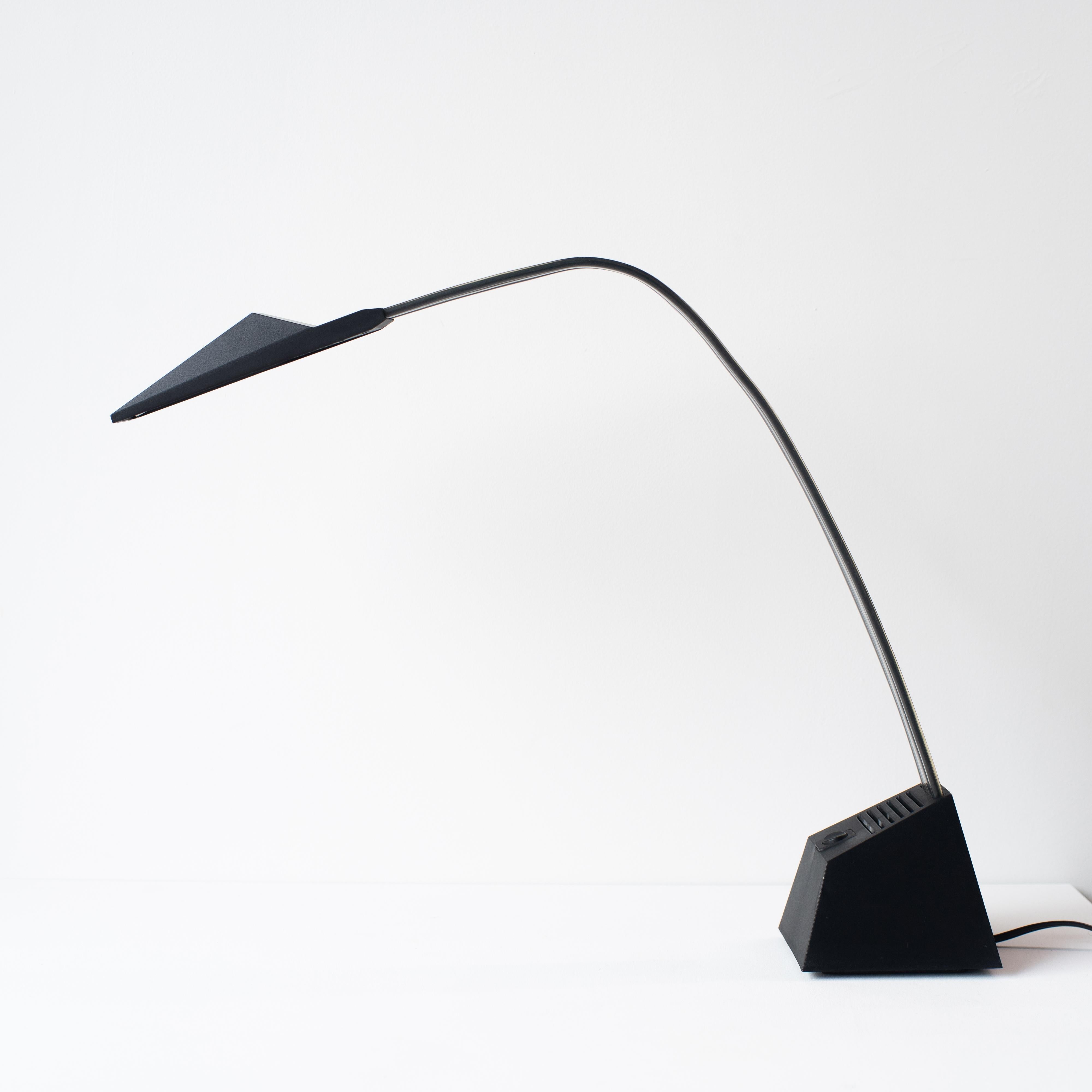 Steel table or desk lamp designed by Arberto Fraser for Stilnovo. It was designed in the 80s. Plastic black and transparent arm is flexible. You can change as you like. 
Famous lighting fixture featured in Taschen 1000 Lights. 

12V halogen bulb.