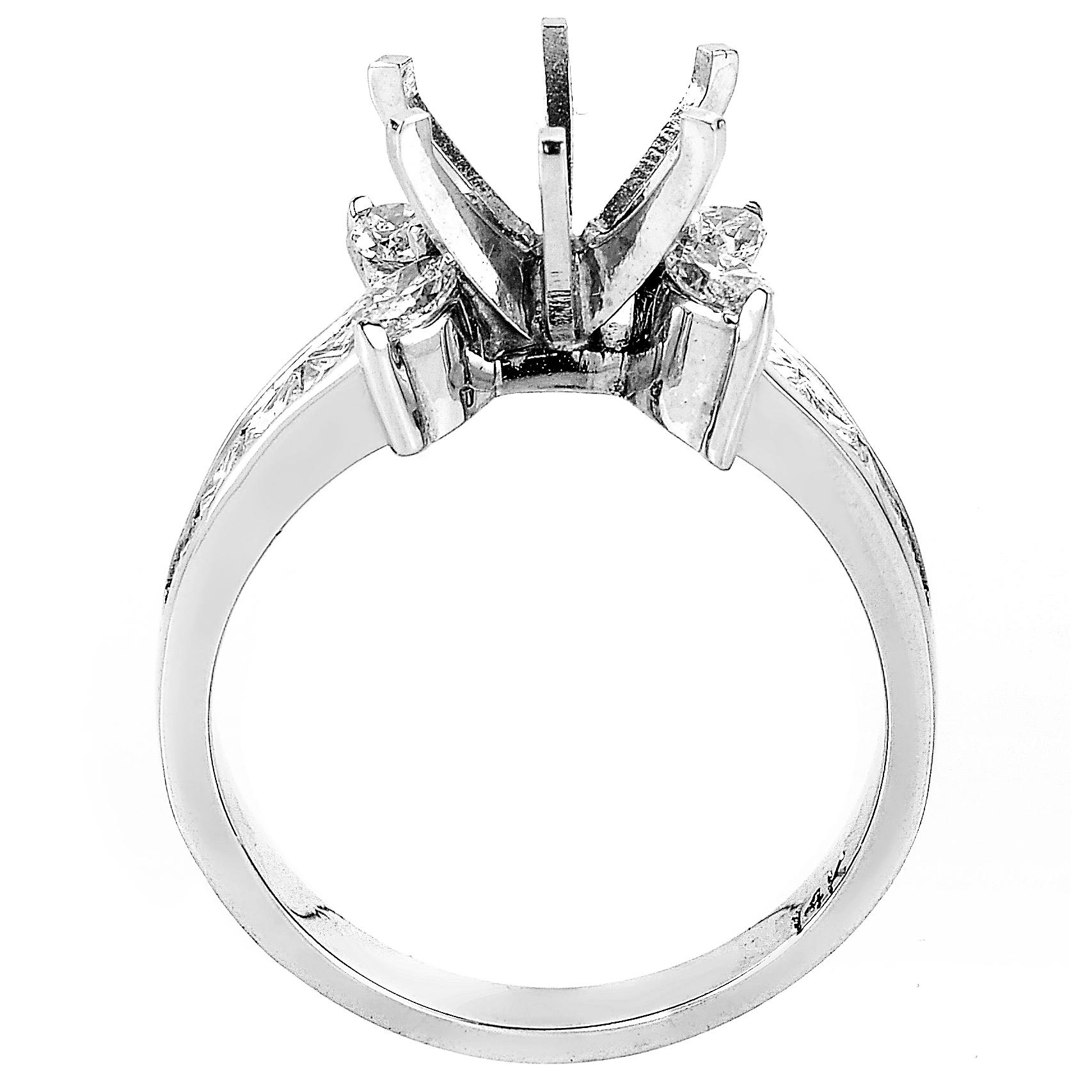 This mounting ring from Natalie K is feminine and flirty. It is made of 18K white gold and boasts diamond sidestones and diamond set shanks. The total diamond carat weight is ~1.05ct of diamonds.
