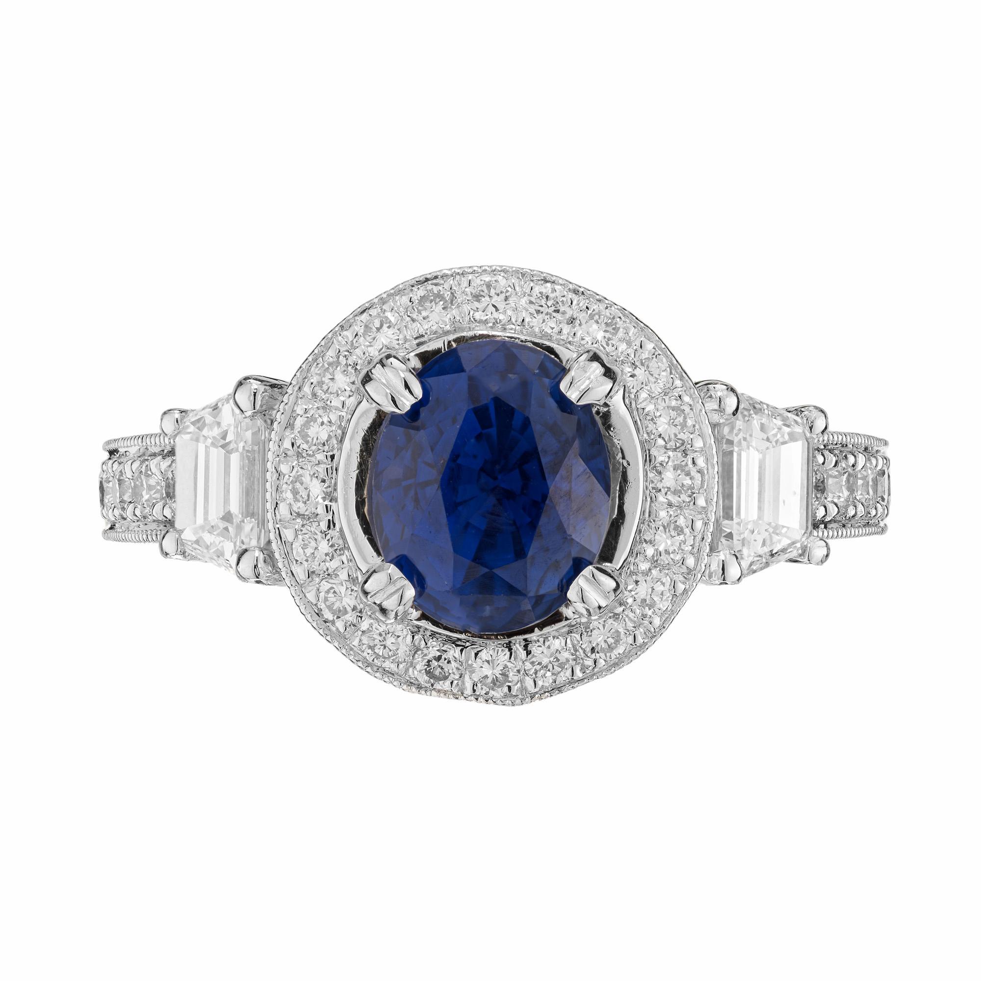 Natalie K oval Sapphire and diamond halo engagement ring. This elegant designer piece begins with a 2.07ct oval center sapphire which is mounted in a platinum bead setting with a halo of round cut diamonds. The sapphire is complimented with a