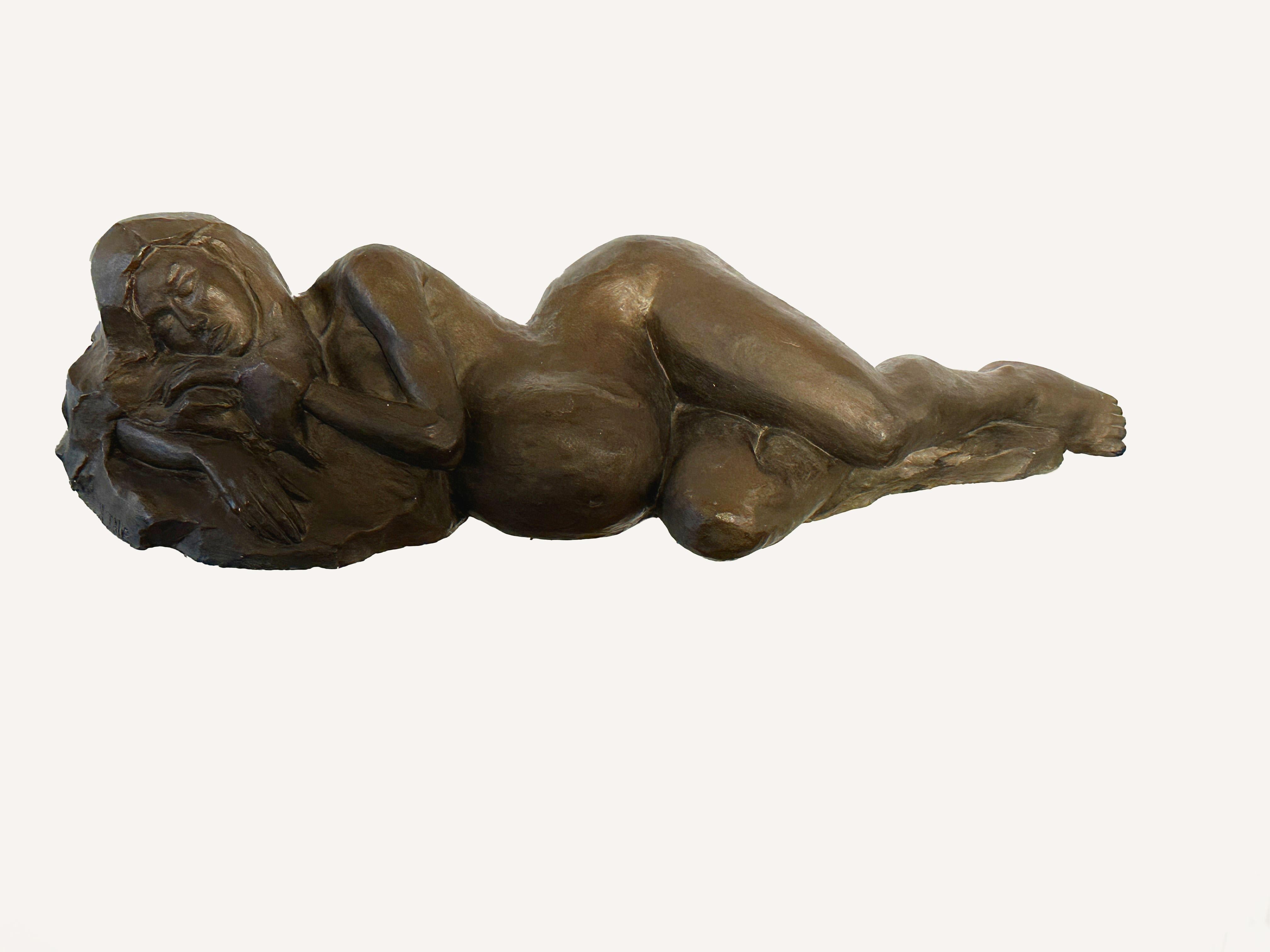 This sculpture by Natalie Krol is made of plaster with a beautiful bronze color finish. It is the cast for the bronze.
It shows a nude, pregnant woman resting. The expression on her face could almost suggest that the artist had surprised her model