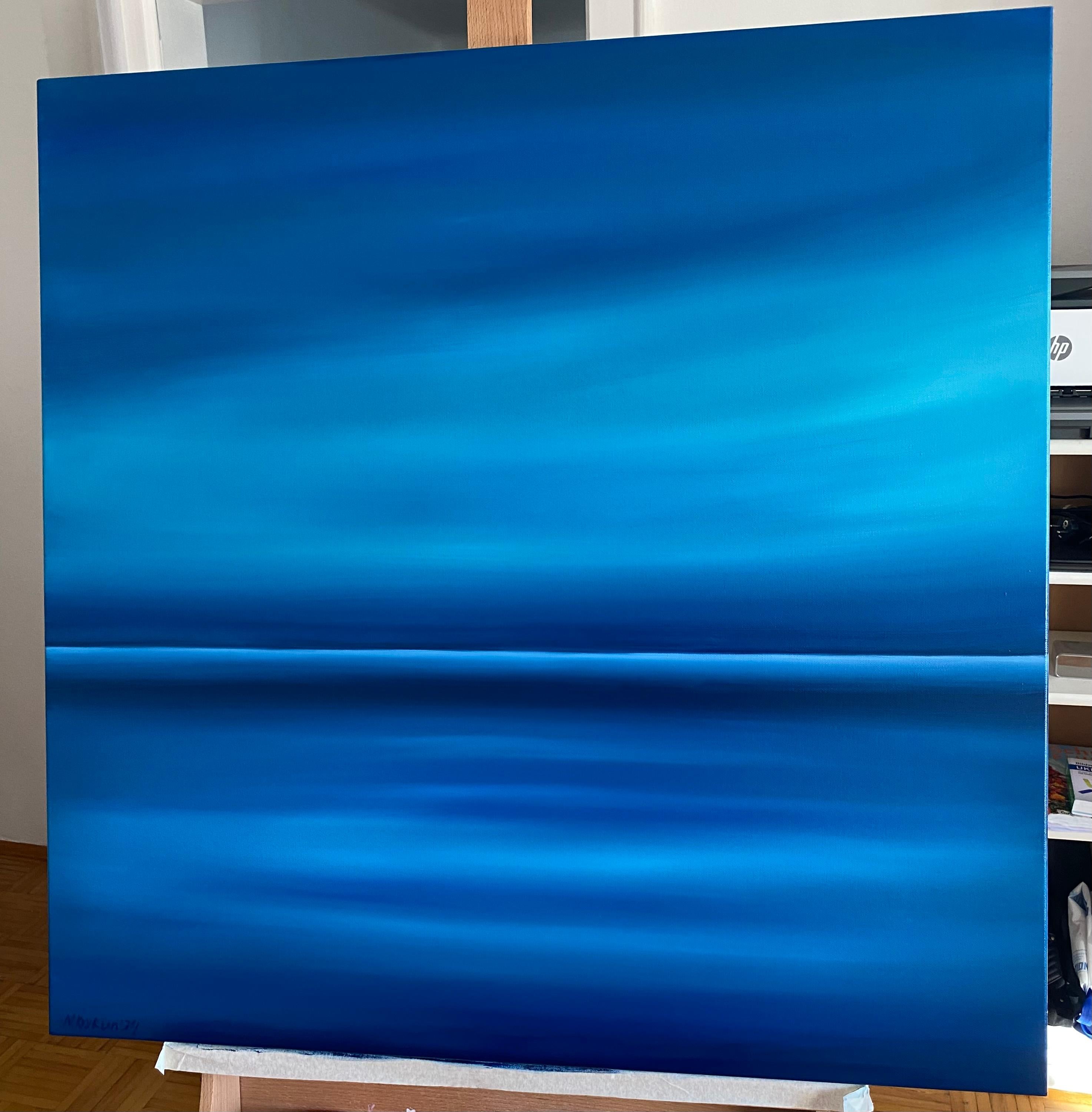 Esta obra de arte presenta una hipnotizante exploración del color y la abstracción, utilizando un espectro de tonos azules para evocar una sensación de calma y espacio infinito. La composición está sutilmente dividida en dos secciones por una