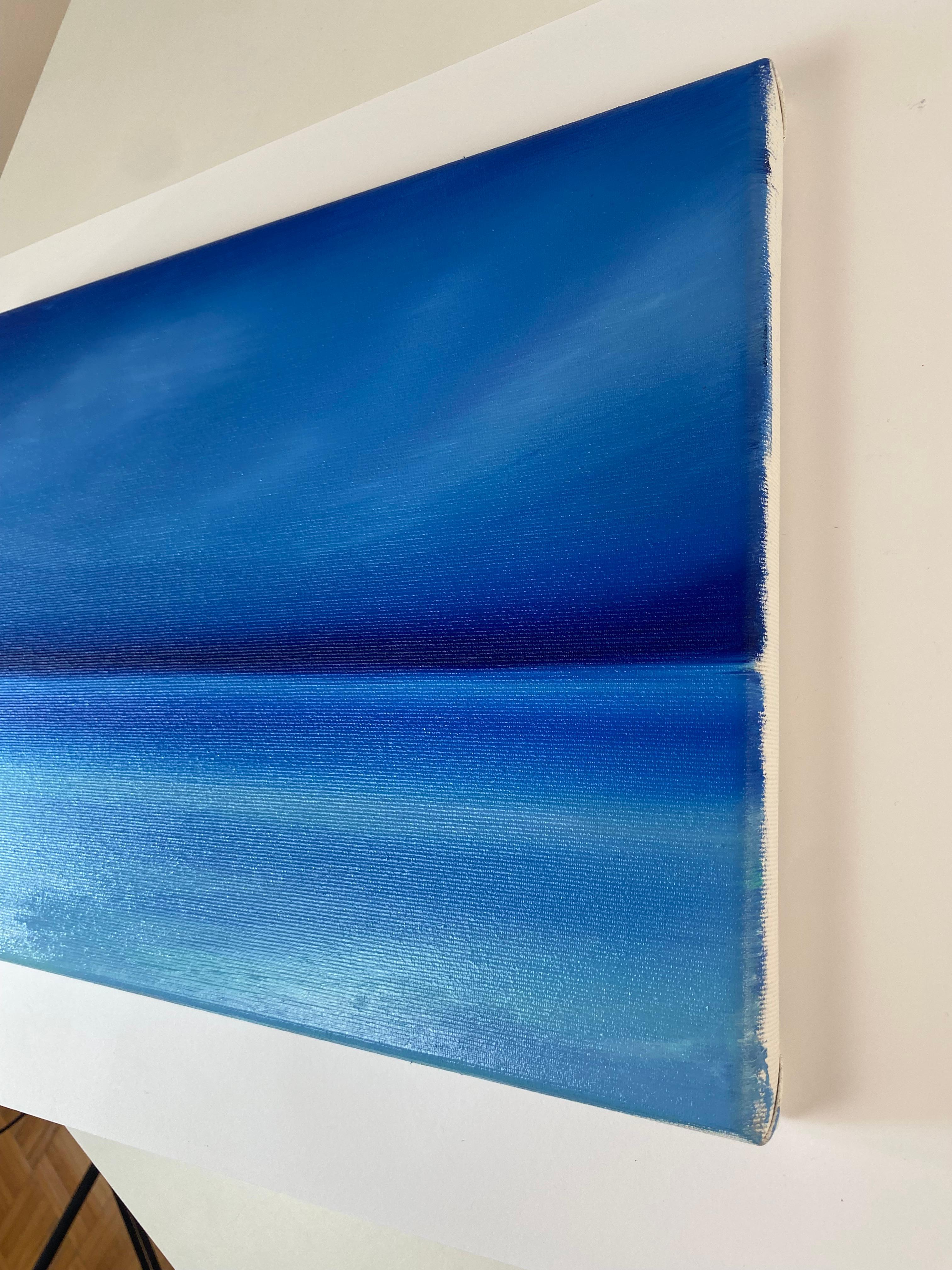 Esta obra de arte presenta una hipnotizante exploración del color y la abstracción, utilizando un espectro de tonos azules para evocar una sensación de calma y espacio infinito. La composición está sutilmente dividida en dos secciones por una