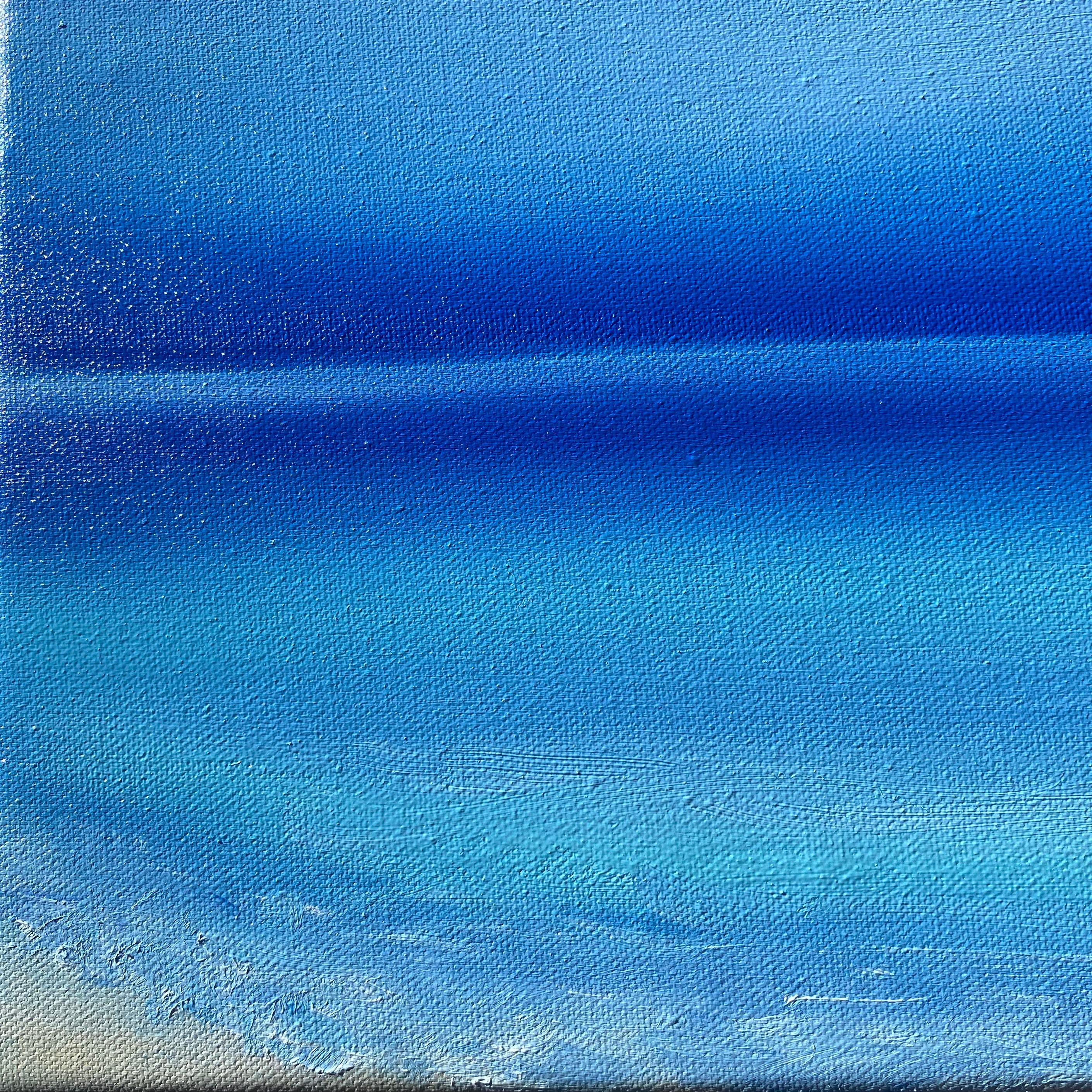 Esta obra de arte presenta una hipnotizante exploración del color y la abstracción, utilizando un espectro de tonos azules para evocar una sensación de calma y espacio infinito. La composición está sutilmente dividida en dos secciones por una