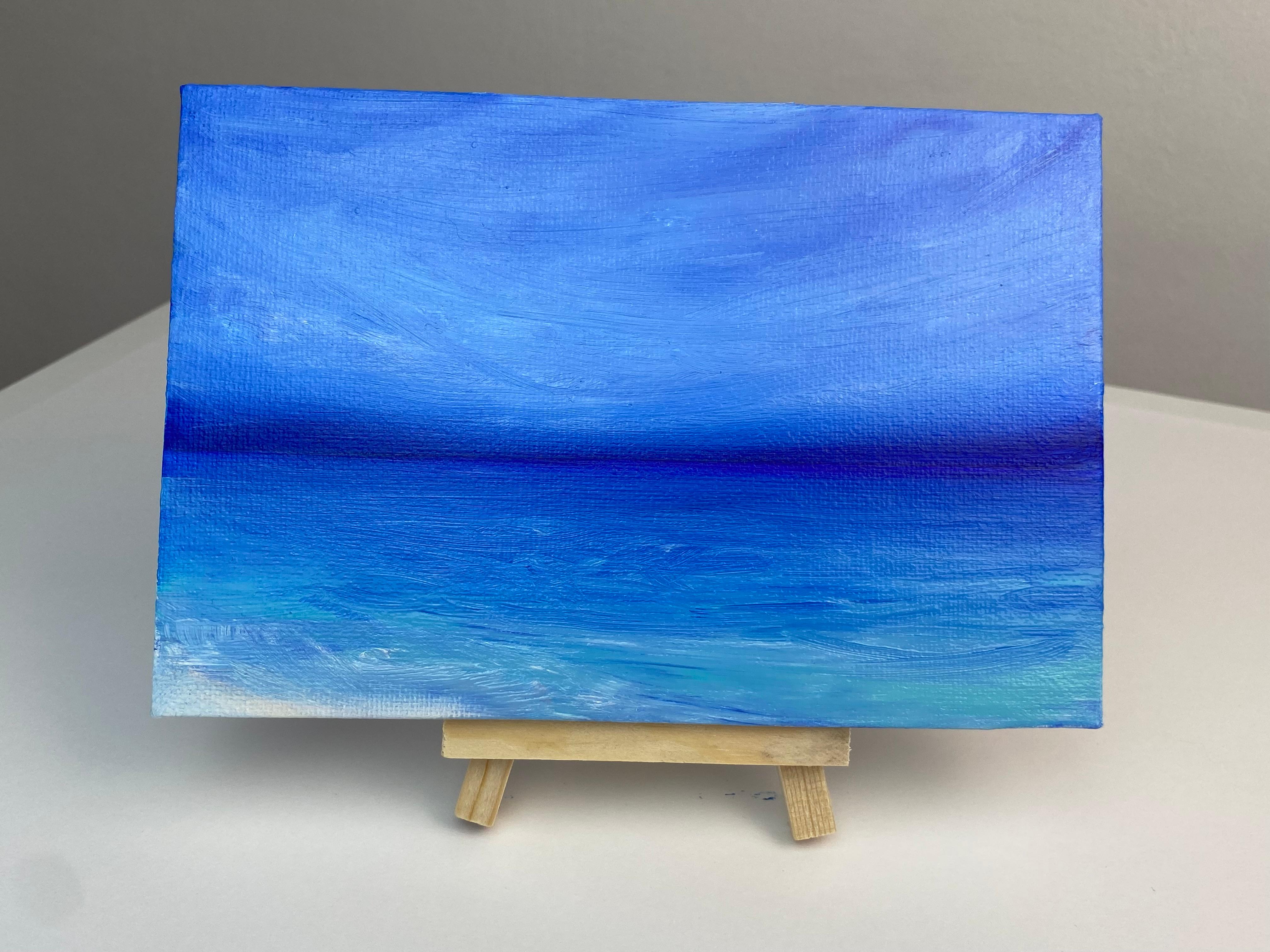Quest'opera d'arte presenta un paesaggio marino sorprendente, magistralmente realizzato con un'ipnotizzante visualizzazione di tonalità blu. La parte superiore del dipinto è dominata da una vasta ed eterea distesa di cielo, resa in varie tonalità di