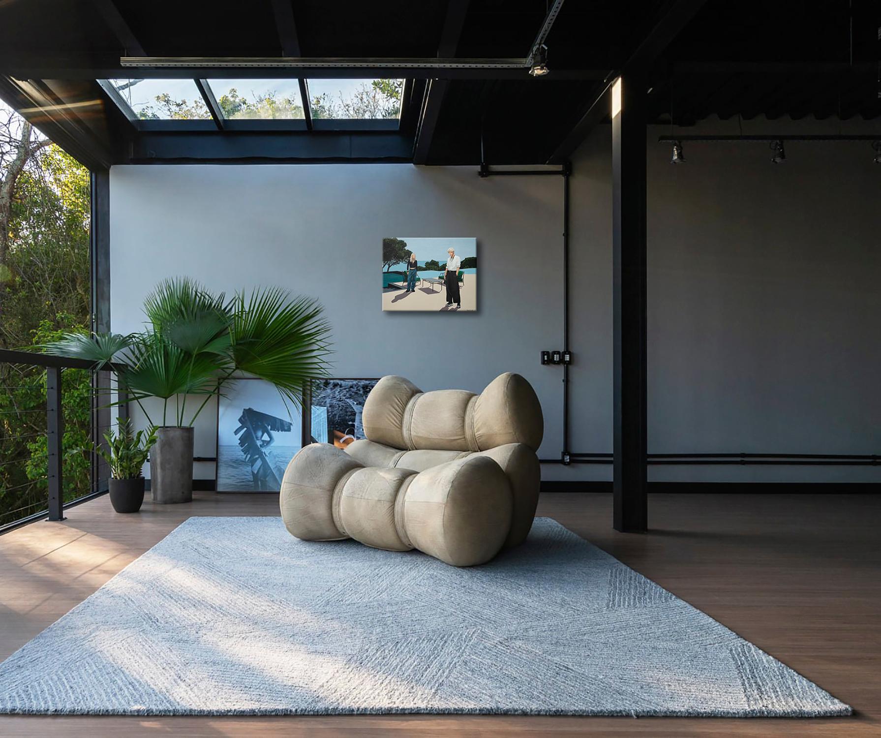 Esta obra de arte representa una serena escena junto a la piscina con dos mujeres jóvenes en una terraza iluminada por el sol y con vistas al océano. Equilibrando el minimalismo moderno y la belleza natural, una irradia elegancia con una camisa