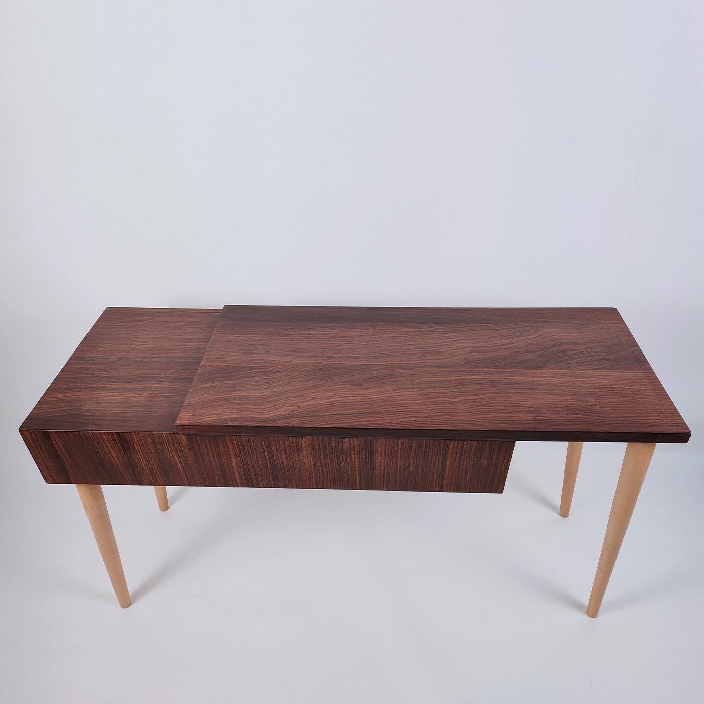 The Natasha Console offers a display-worthy design that takes a unique approach on a traditional wooden console. Handcrafted of prized rosewood, the distinctive top is split on two levels, one featuring a large handless drawer with solid beech