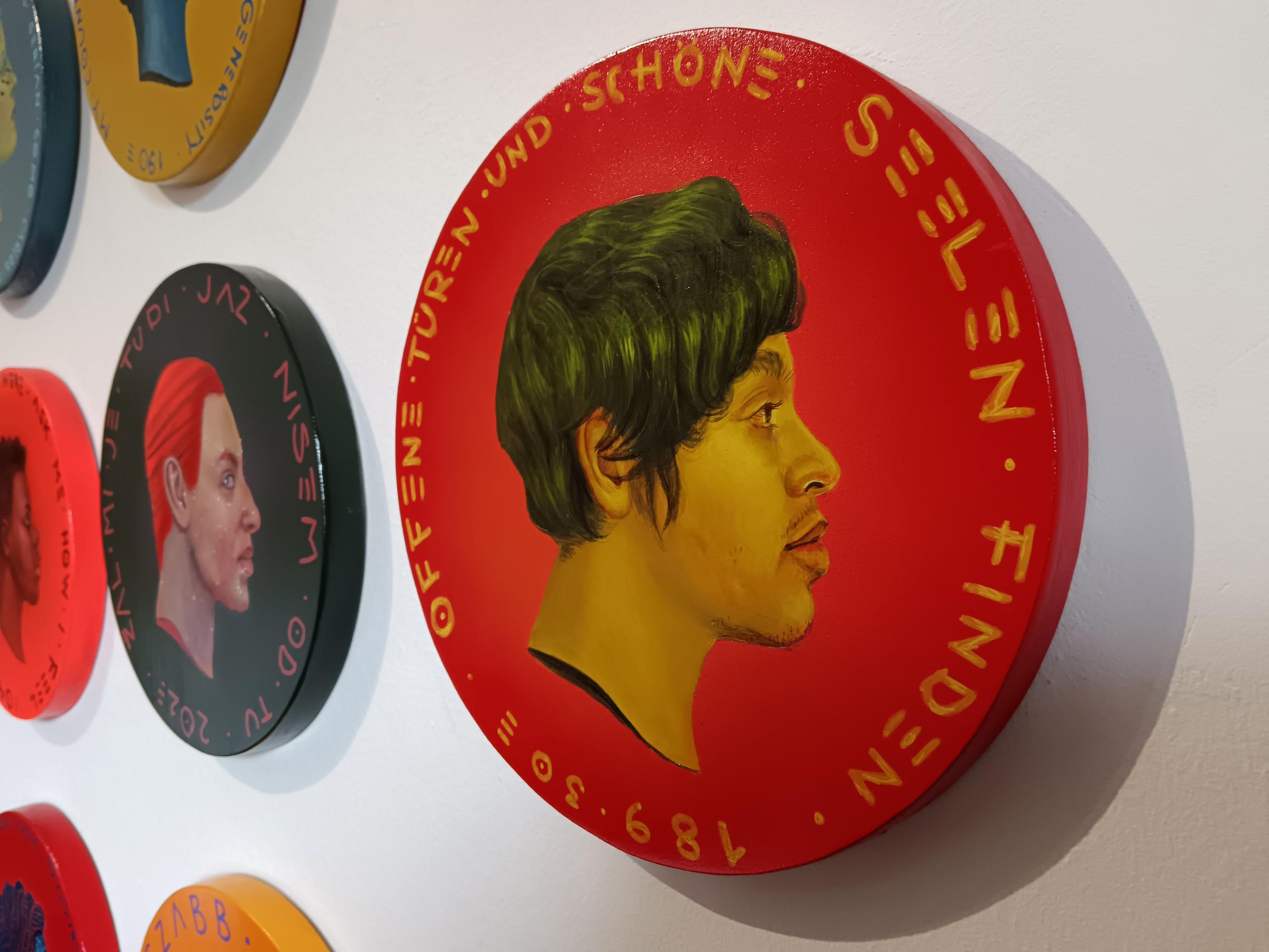 This piece from Natasha Lelenco's Exchange Currencies series, painted in acrylic with yellow and ochre tones against an intense red background, features a hyperrealistic profile portrait of a young person on a 26cm wooden piece that emulates a coin.