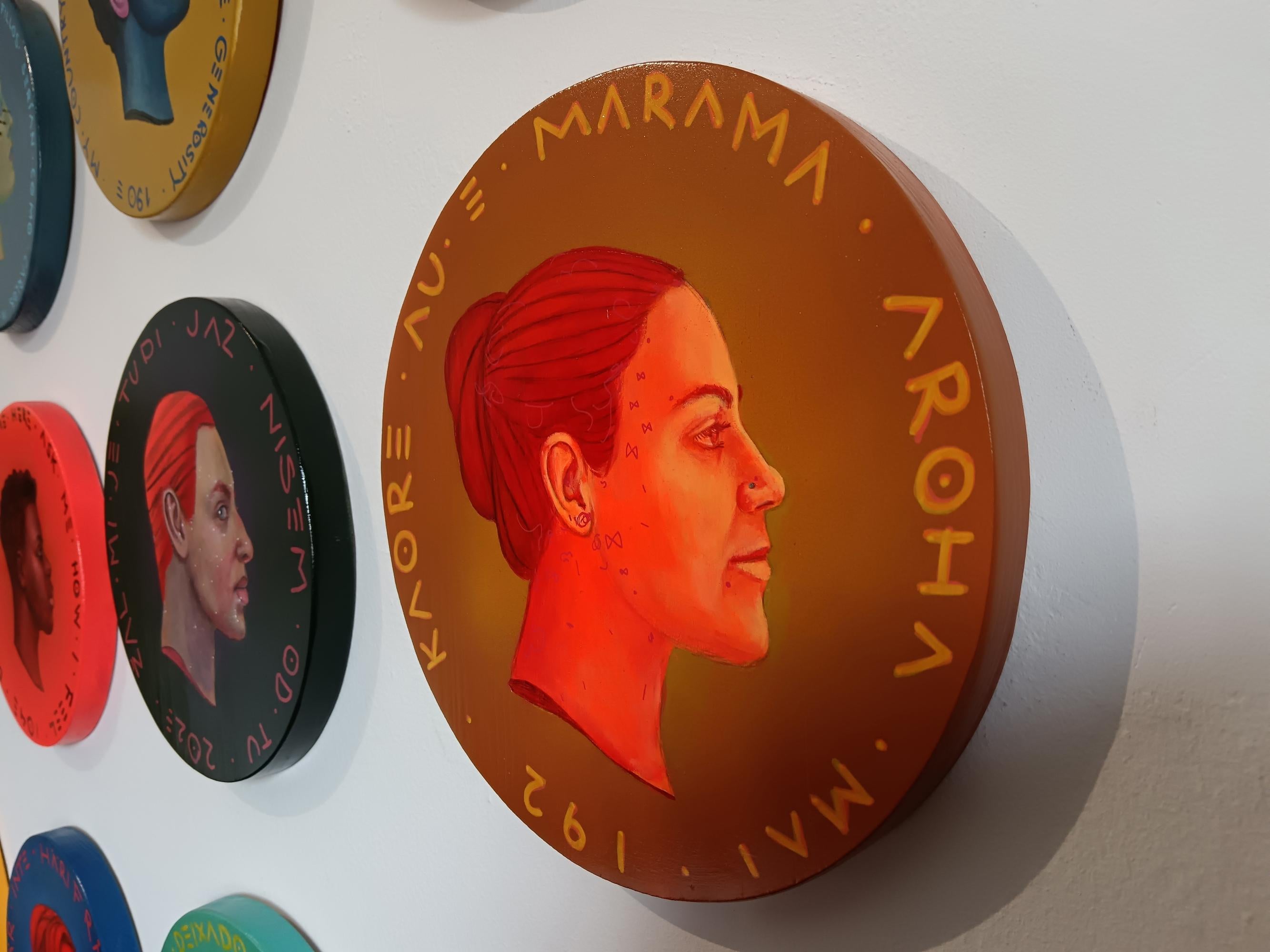 This piece, belonging to Natasha Lelenco's Exchange Currencies series, features a profile portrait of a woman on a circular wooden surface that emulates a coin. On the coin, the Maori phrase 