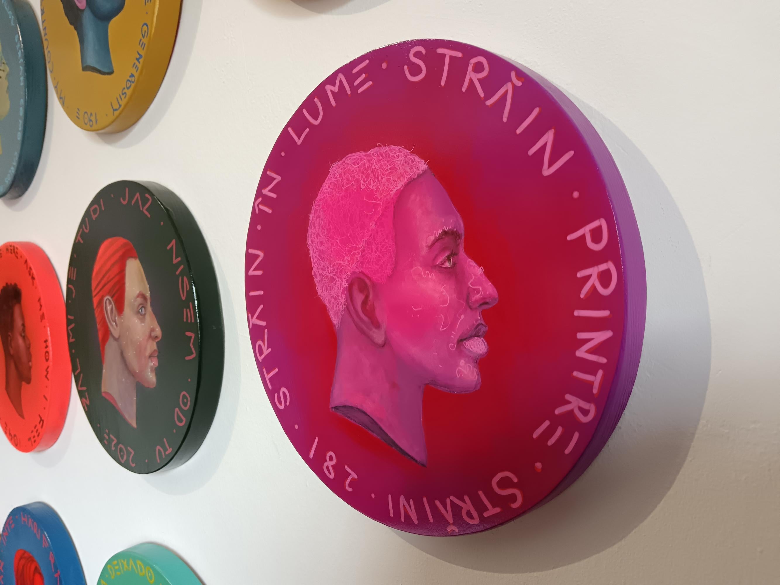 This sculptural painting, part of Natasha Lelenco's Currency Exchange series, consists of a profile portrait on a wooden tondo with intense fluorescent pink colors of a character framed by the Romanian phrase 