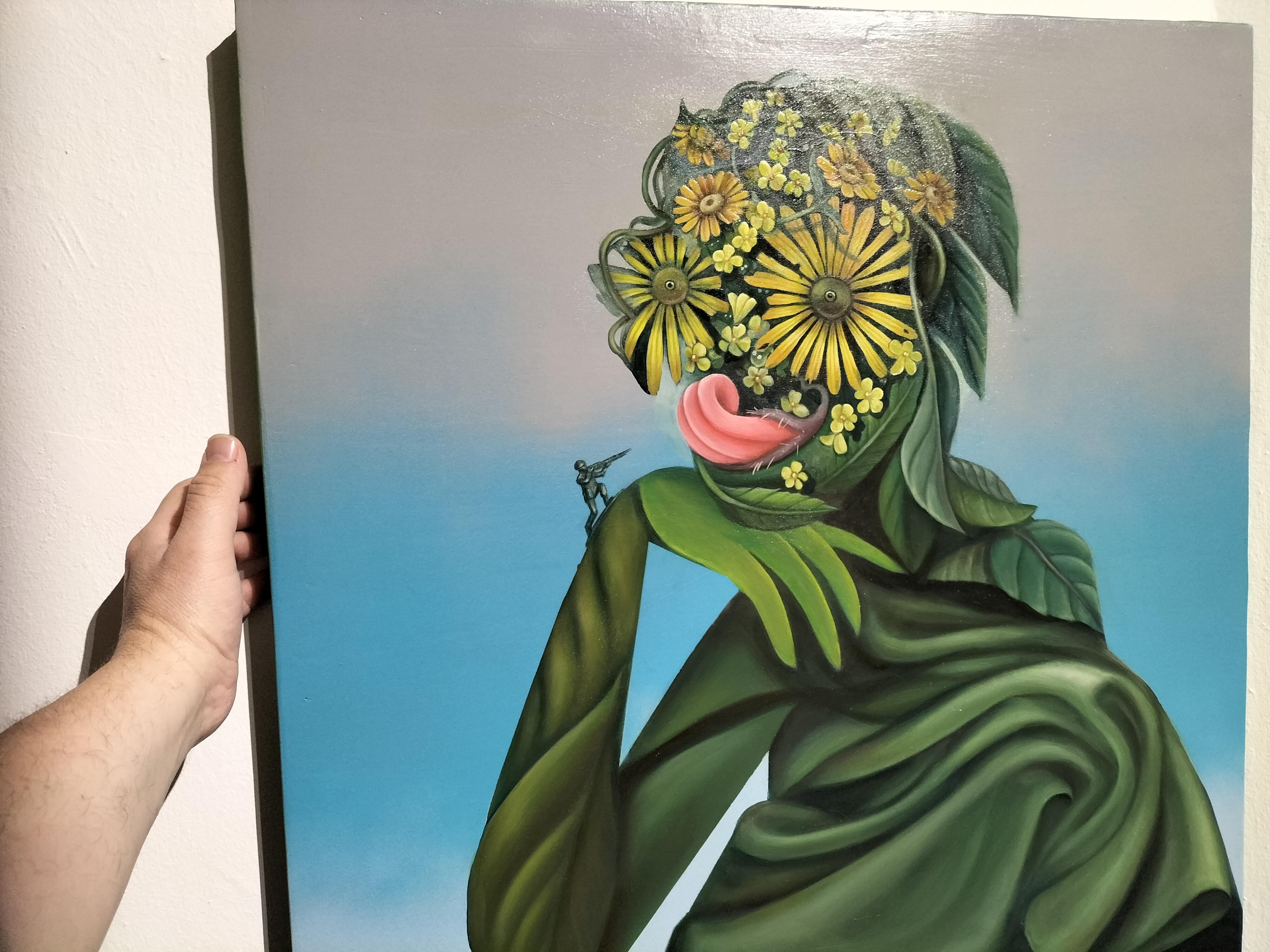 Questo sorprendente dipinto in acrilico dell'artista moldavo-spagnola Natasha Lelenco presenta un surreale ritratto antropomorfo costruito con foglie verdi e margherite gialle in fiore, mescolando precisione botanica e intensità simbolica. Il volto