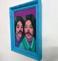 Cuadro enmarcado de un retrato doble con bigote a juego, ojos de emoji y marco azul