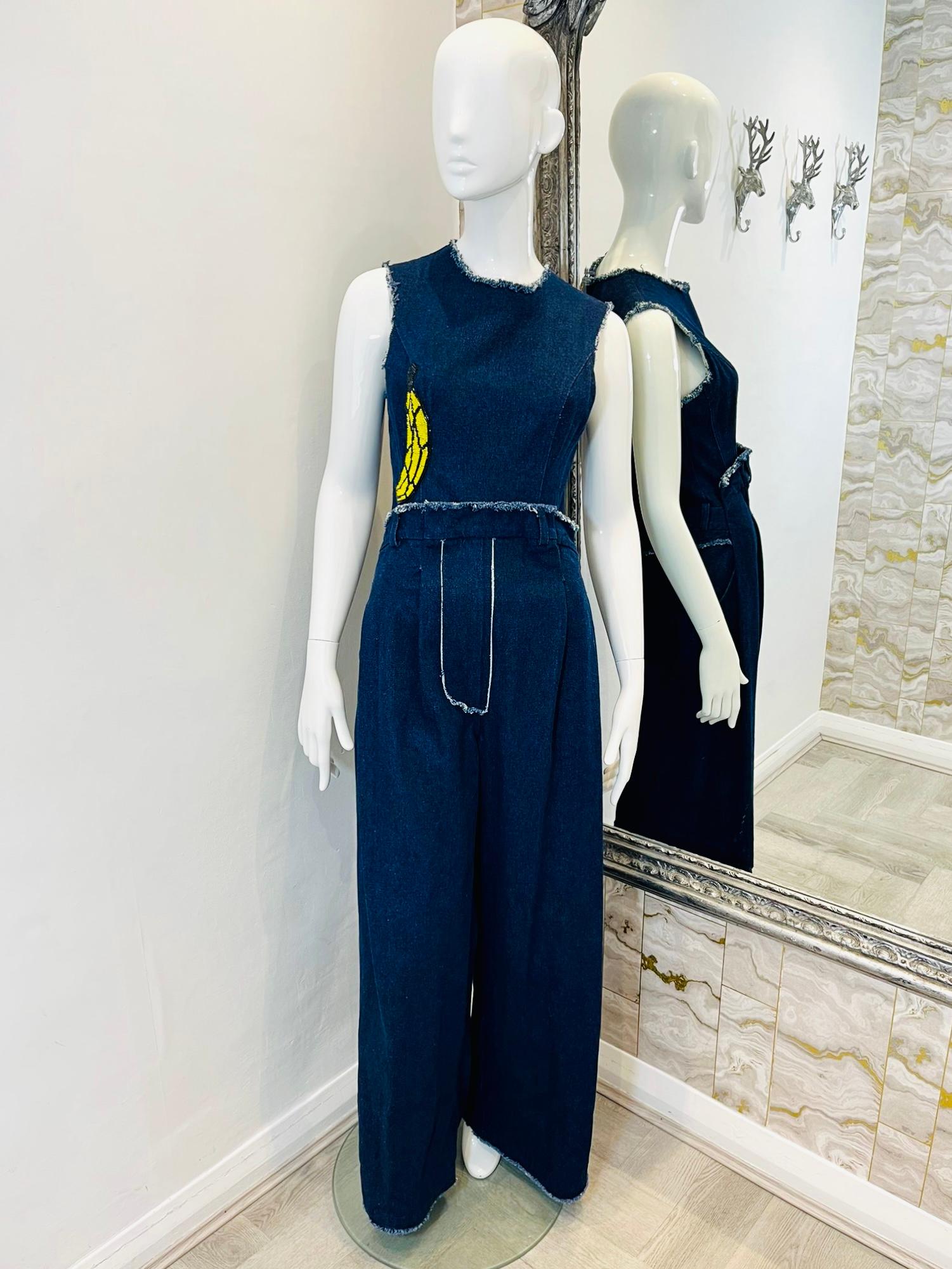 Natasha Zinko Banana Applique Denim Jumpsuit

 Dark blue denim with fringed trim, wide leg jumpsuit with four pockets

and featuring a fully beaded Banana detailing. Gold zipper closure and belt hoops 

to waist.

Size - 10UK

Condition -