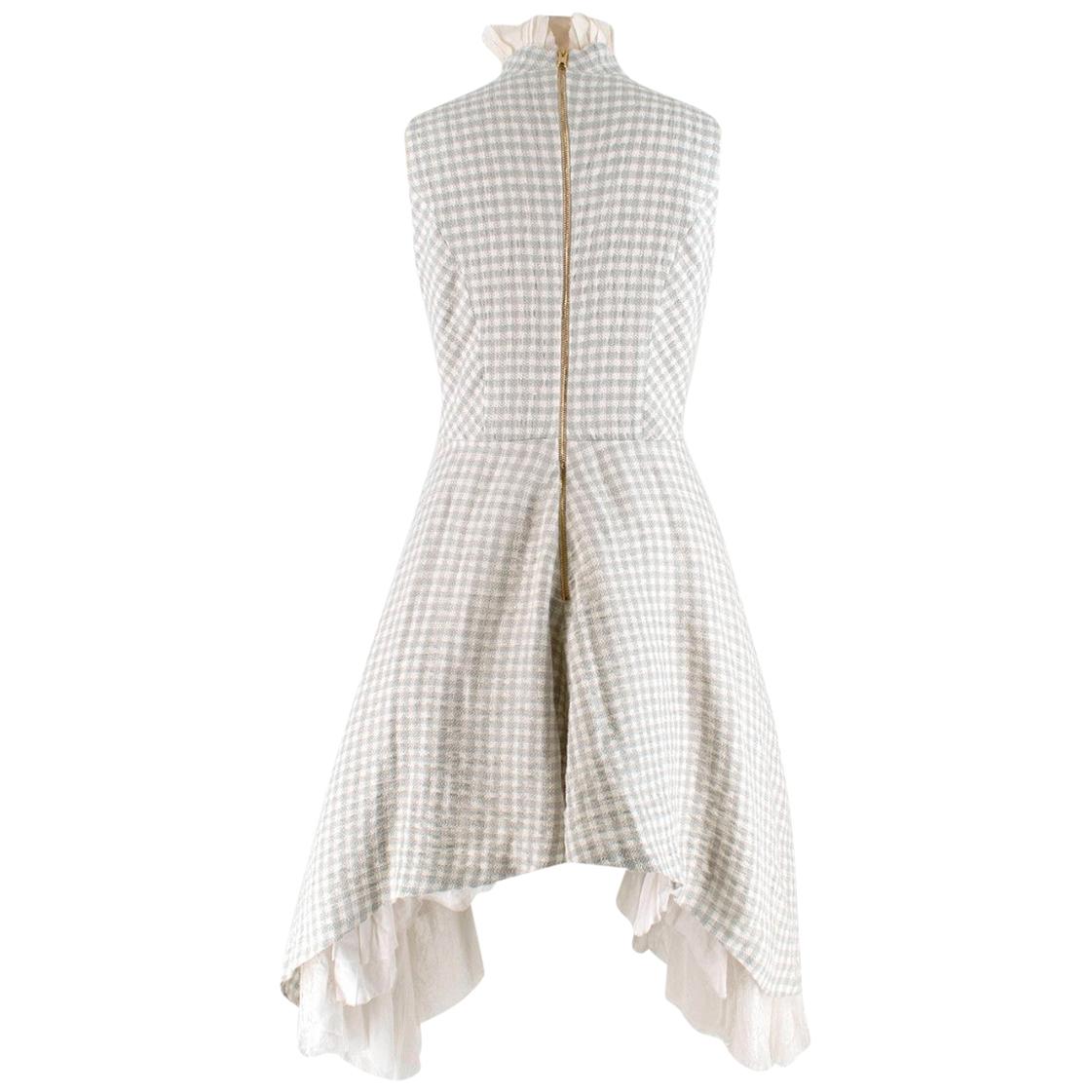 Natasha Zinko Grey Checked Sleeveless Dress
- Grey and white checked woven pattern
- Pearlescent buttons down the front 
- White ruffled trimming with exposed threading 
- Lined and netted skirt
- Ruffle front detail 
- High neck

Materials
100%