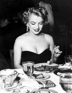Marilyn Monroe sitzend am Tisch