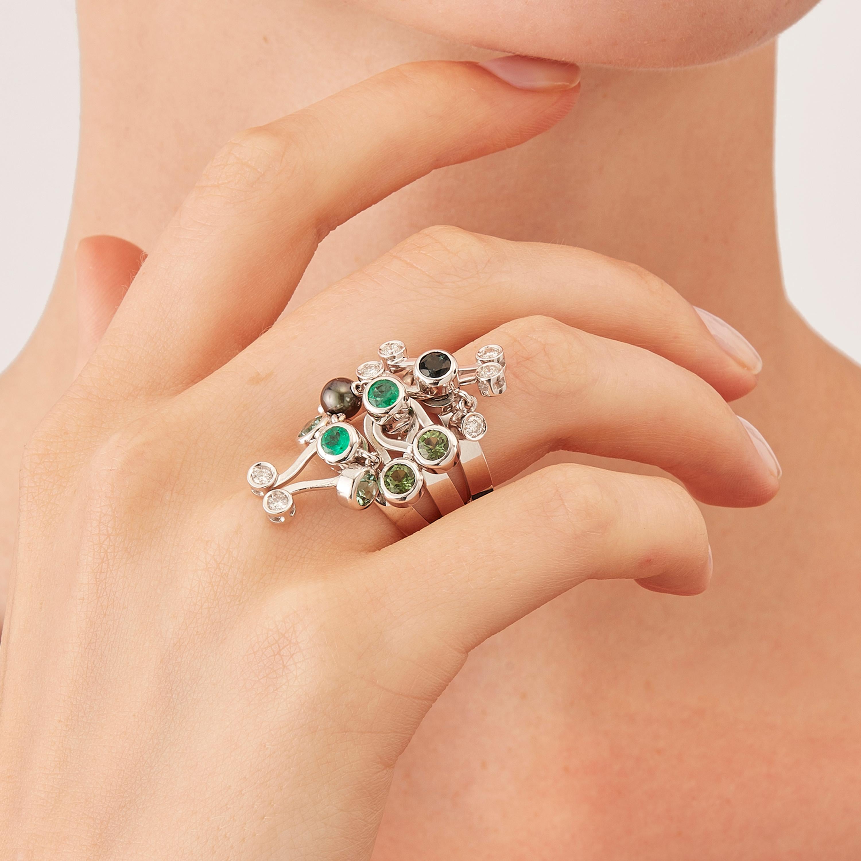 Microrock Three Multi-Stone Rings are devised as a game, a construction or a sophisticated aerial mobile. Shapes attached to gold rings dangle lightly on the hand, their sculptural geometry pierced by diamond (carat total weight 0,35), green